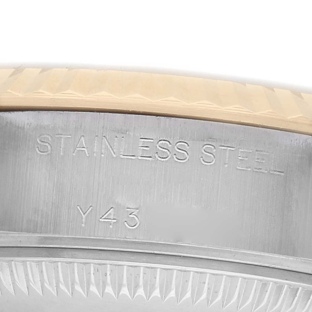 The image shows a close-up of the case side of a Rolex Datejust 79173 Women
s Steel and Gold (two tone) Champagne Dial watch, highlighting the "STAINLESS STEEL" engraving.