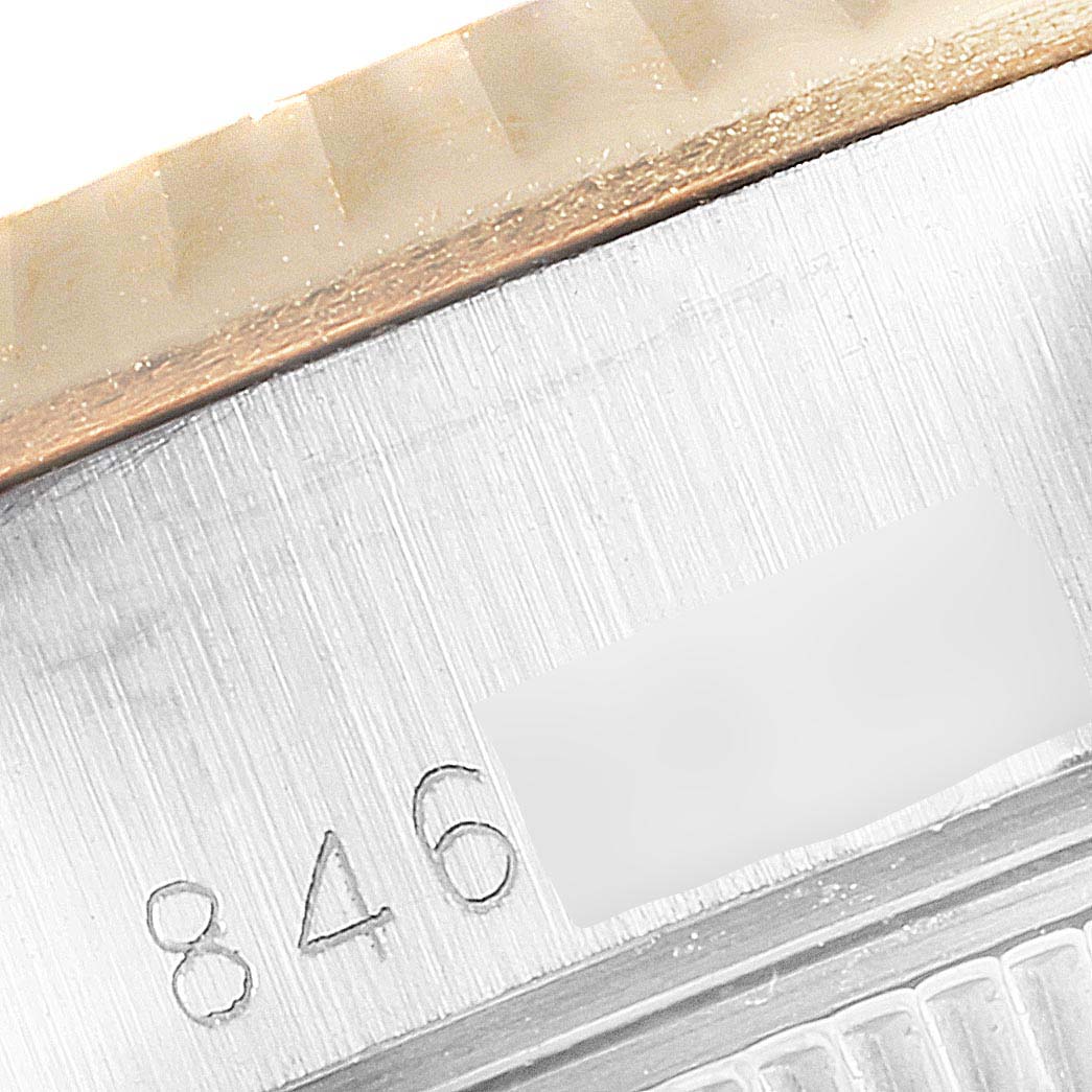 This close-up image of the Rolex Datejust 69173 Women
s Steel and Gold (two tone) Silver Dial 69173 Women
s Steel and Gold (two tone) Silver Dial watch shows part of the bezel and the serial number engraving.