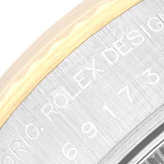 The image shows a close-up angle of the side of a Rolex Datejust 69173 Women's Steel and Gold (two tone) Champagne Dial 69173 Women's Steel and Gold (two tone) Champagne Dial model, focusing on the engraved text and bezel.