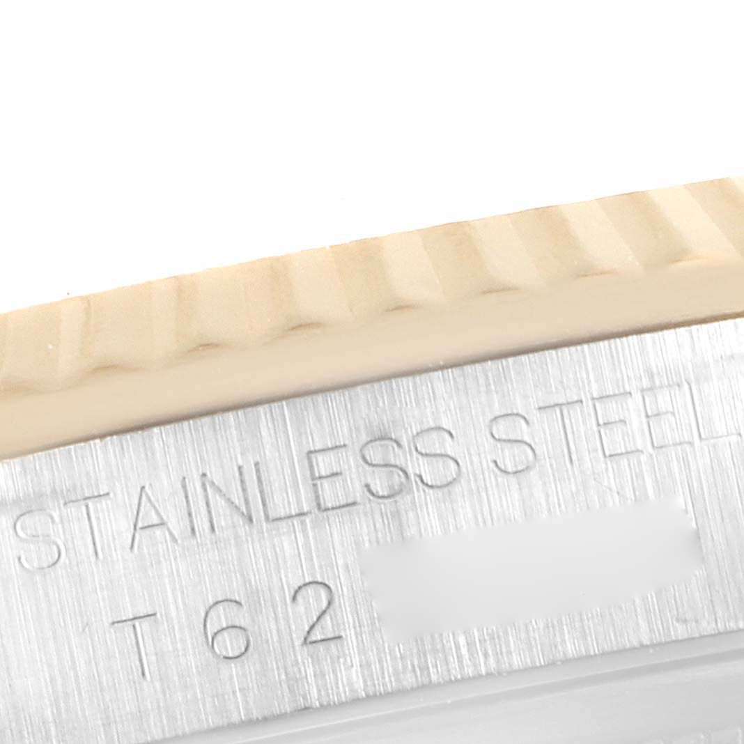 This close-up image of the Rolex Datejust 16233 Men's Steel and Gold (two tone) White Dial 16233 Men's Steel and Gold (two tone) White Dial watch shows the fluted bezel and the engraved text on the stainless steel caseback.