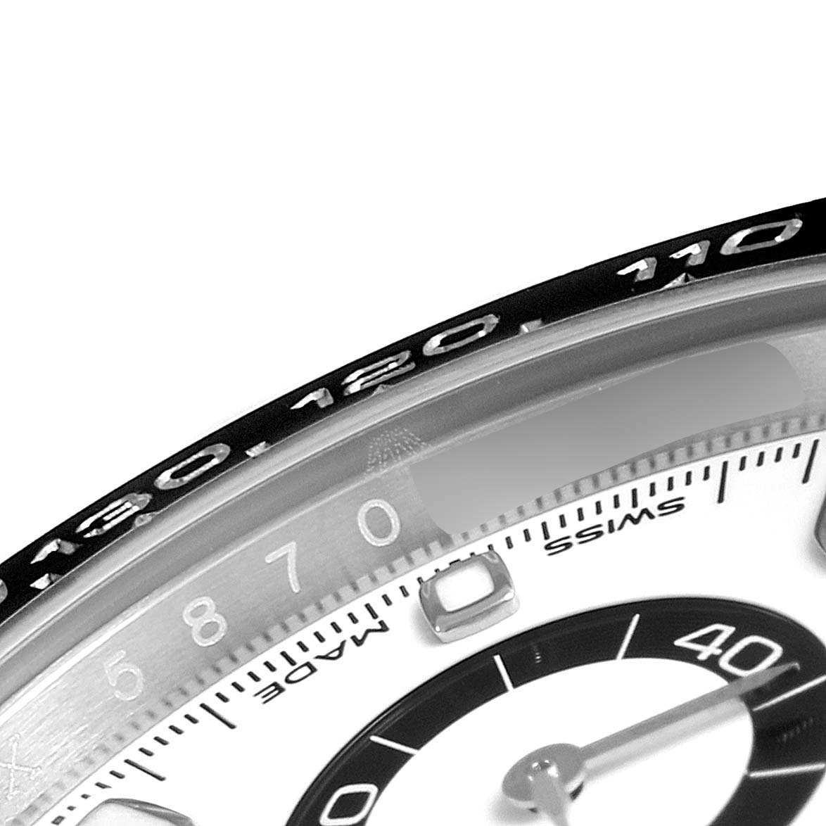 The image is a close-up of the bezel, part of the dial, and subdial of a Rolex Daytona 116500 Men's Stainless Steel White Dial 116500 Men's Stainless Steel White Dial watch.