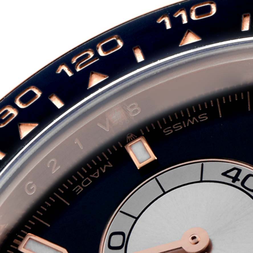 The image shows a close-up of the Rolex Daytona 126515 Men
s Rose Gold Black Dial
s bezel and part of the dial with its scale and hand.