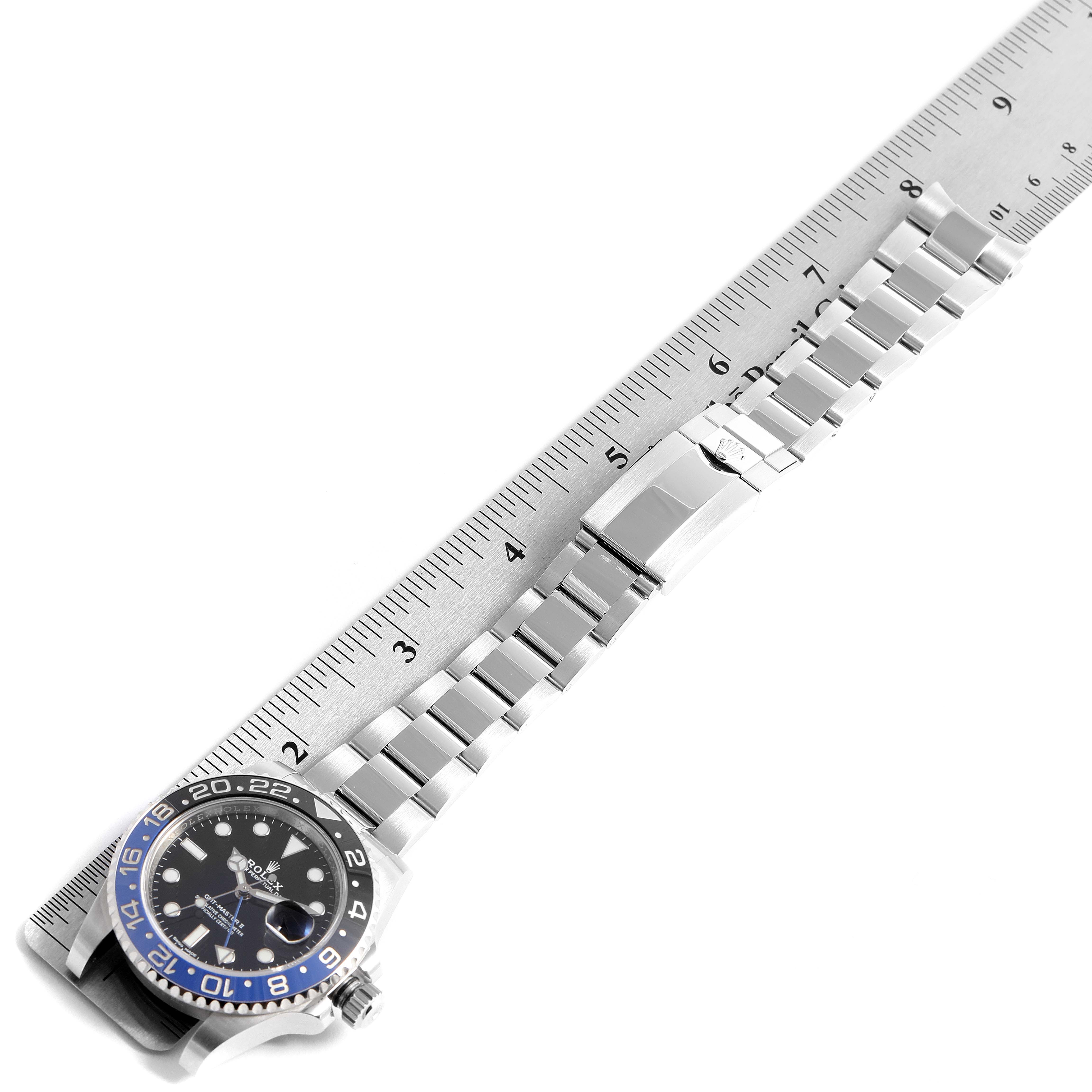 The image shows a Rolex GMT-Master 116710 Men's Stainless Steel Black Dial 116710 Men's Stainless Steel Black Dial watch and its metal bracelet placed parallel to a ruler for measurement.