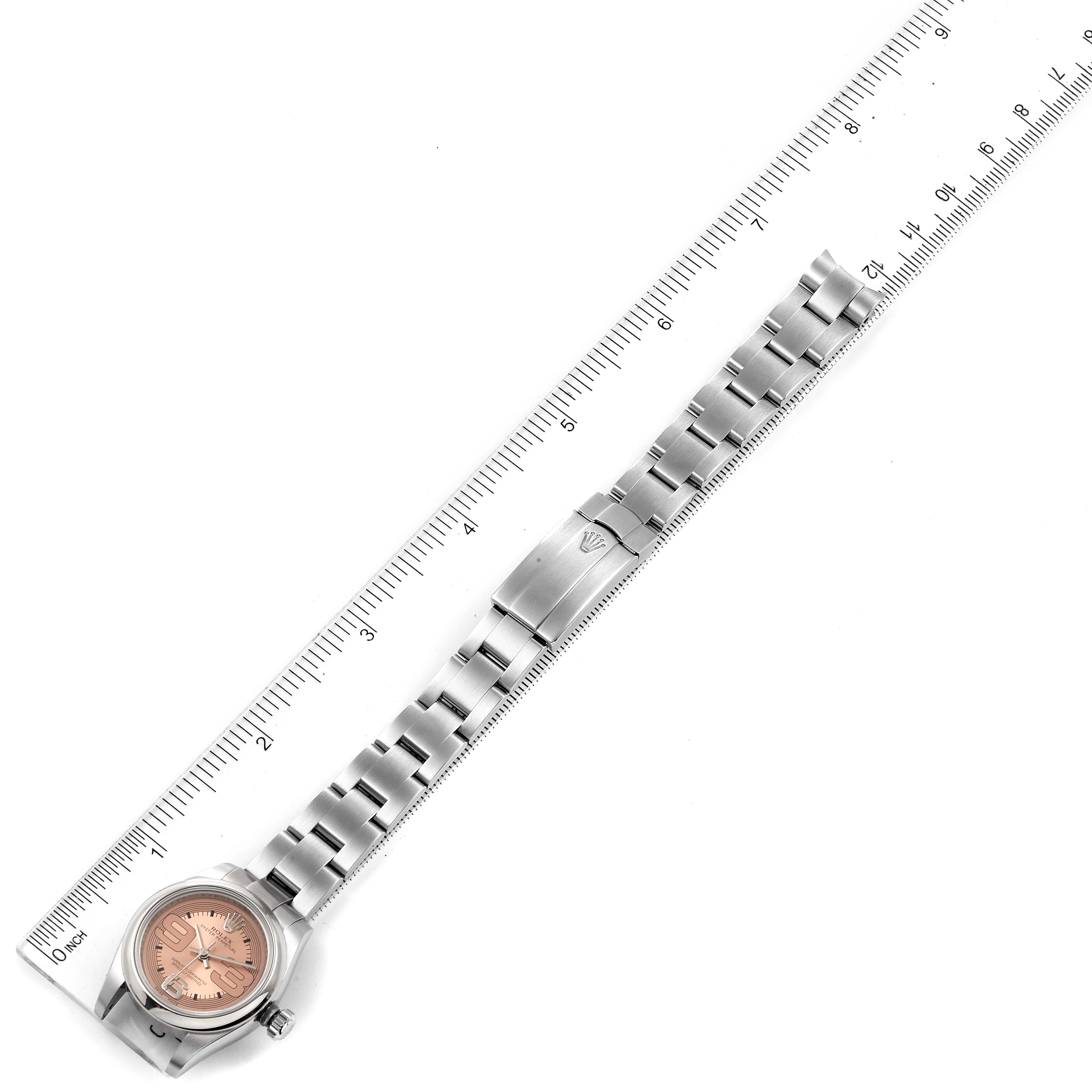 The image shows a top-down view of a Rolex Oyster Perpetual 176200 Women's Stainless Steel Pink Dial 176200 Women's Stainless Steel Pink Dial watch and its bracelet, with a ruler for scale.