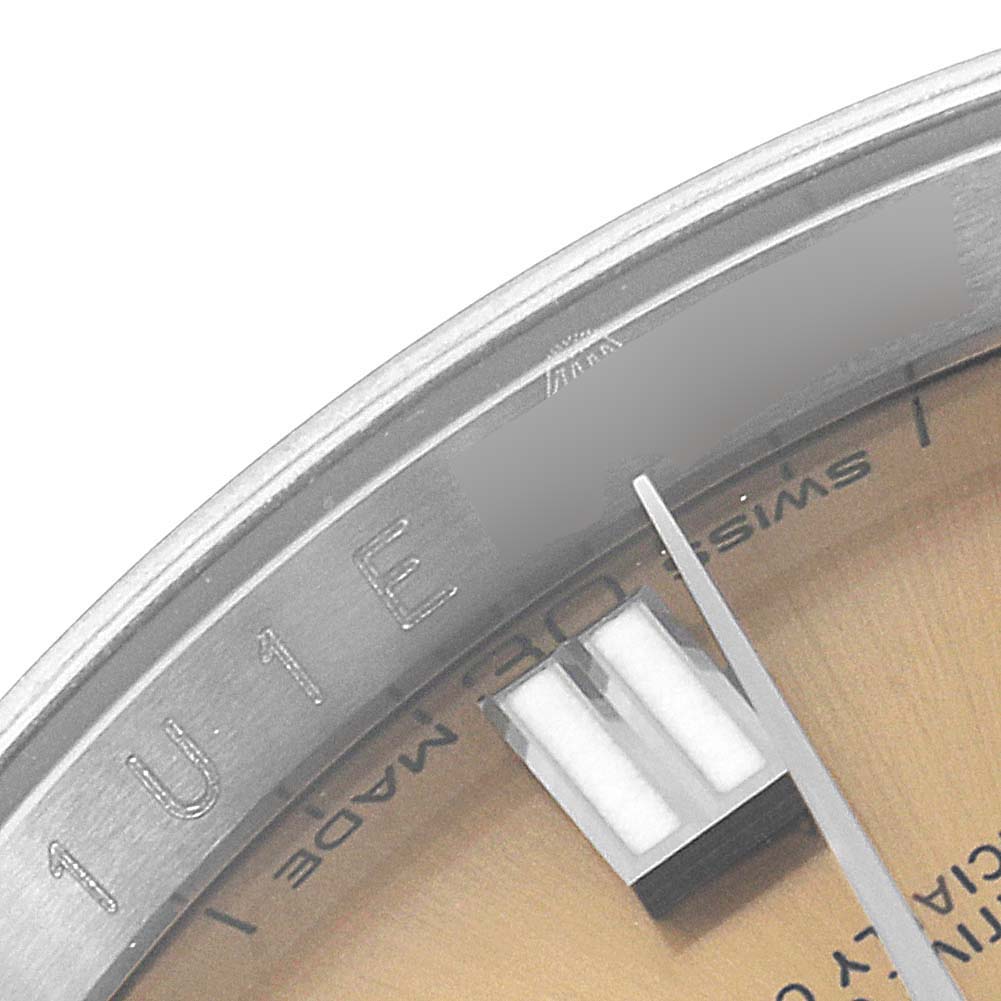 This close-up shows the dial and bezel of a Rolex Oyster Perpetual 116000 Men's Stainless Steel Champagne Dial 116000 Men's Stainless Steel Champagne Dial watch, highlighting the minute markers and part of the second hand.