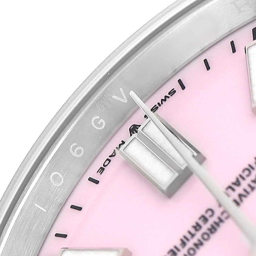 This close-up shows the dial and hands of a Rolex Oyster Perpetual 134300 Men's Stainless Steel Pink Dial watch, highlighting the pink face and hour markers.