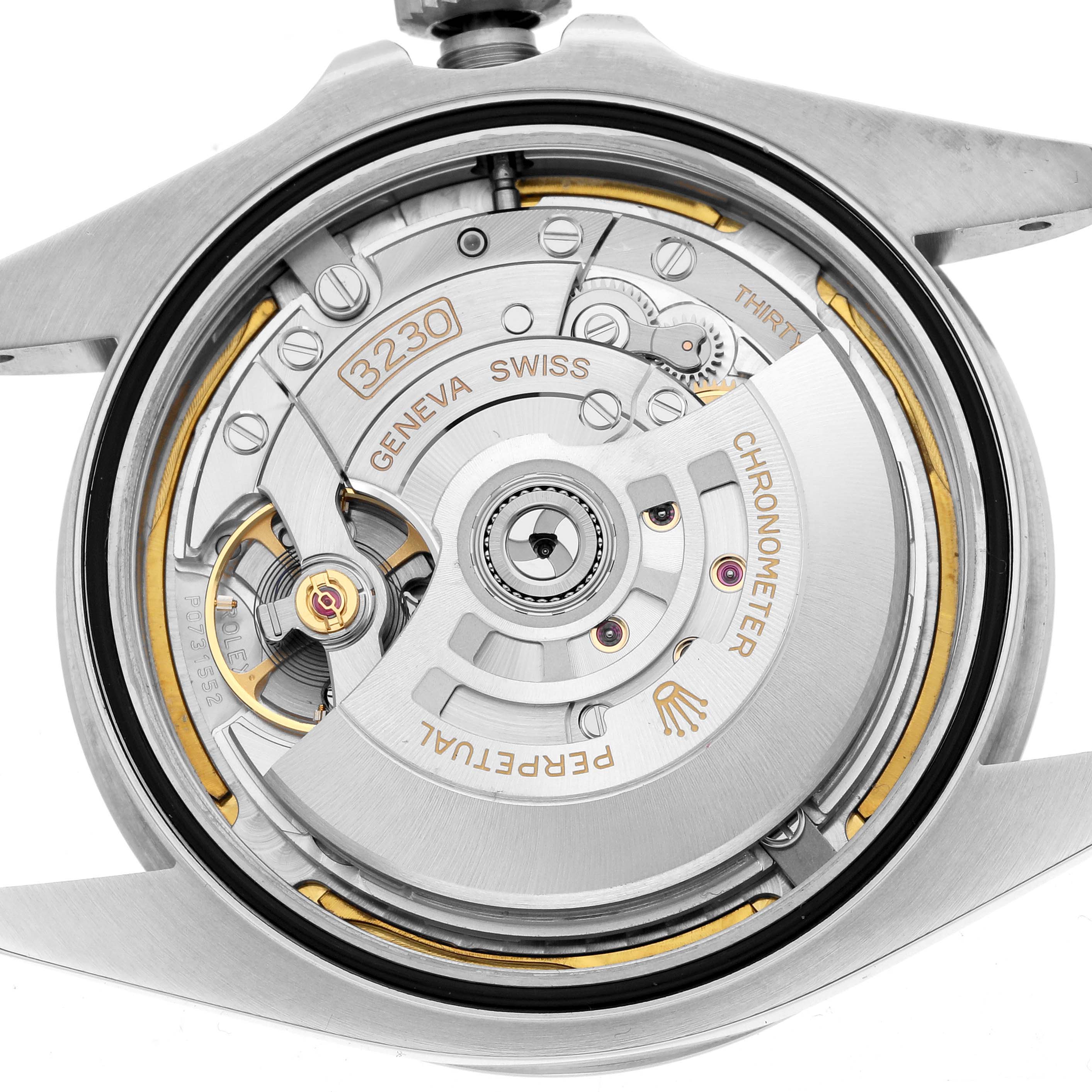 The image shows the movement of a Rolex Air-King 126900 Men
s Stainless Steel Black Dial watch from a case-back angle, highlighting the intricate mechanics and engravings.