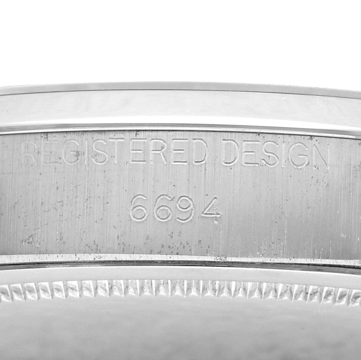 The image shows a close-up of the side casing of a Rolex Vintage Collection 6694 Men
s Stainless Steel Silver Dial watch, displaying the engraved design number 6694.
