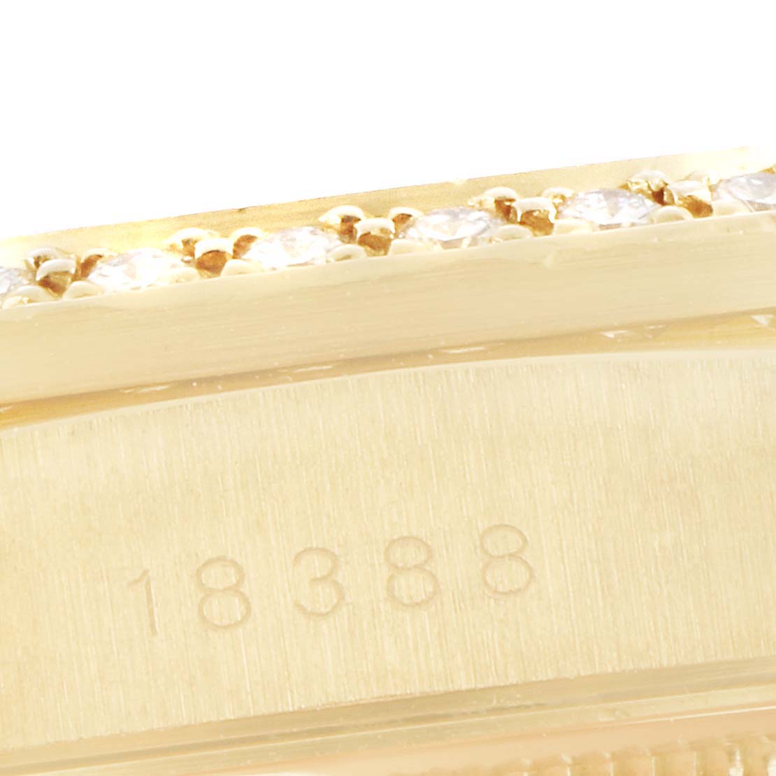 This close-up shows the side of a Rolex President 18388 Men
s Yellow Gold Black Dial 18388 Men
s Yellow Gold Black Dial watch, highlighting its serial number and diamond-set bezel.