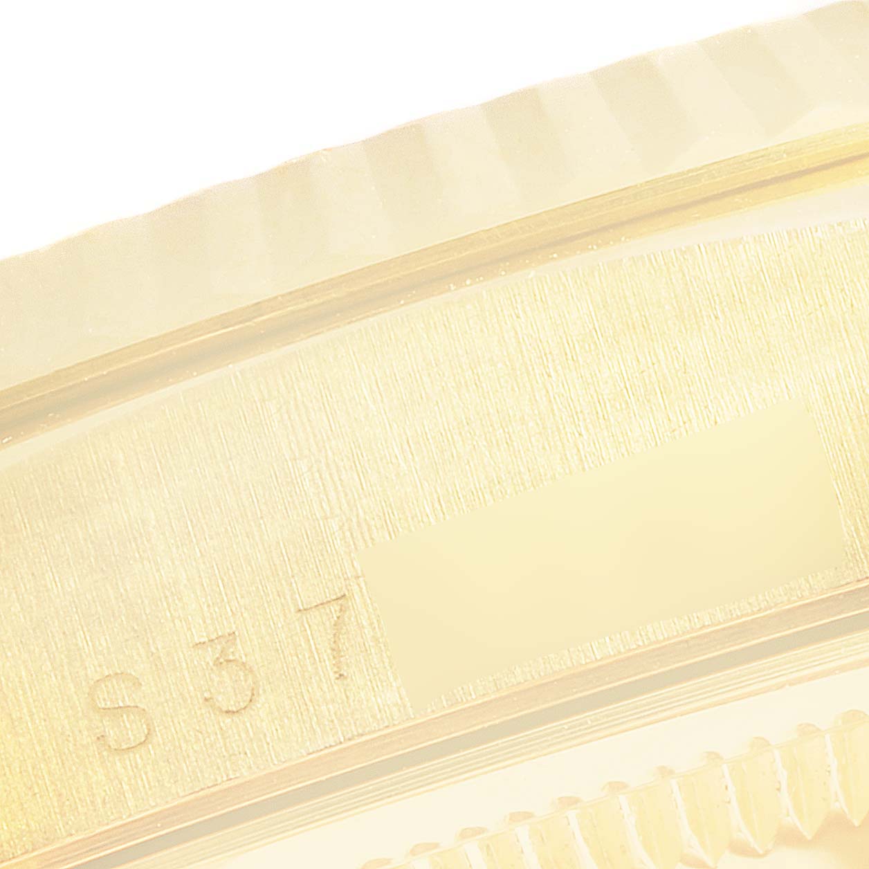 This image shows a close-up of the side of a Rolex President 18238 Men
s Yellow Gold Champagne Dial 18238 Men
s Yellow Gold Champagne Dial model watch, focusing on part of the casing and serial number.