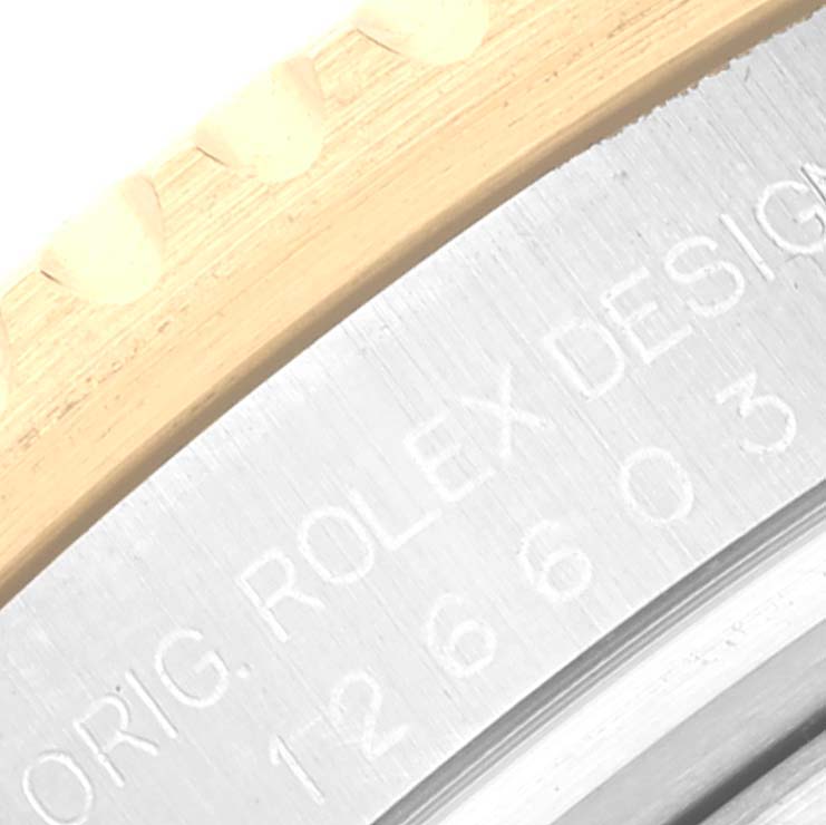 The image shows a close-up of the bezel and engraved case edge of a Rolex Sea-Dweller 126603 Men
s Steel and Gold (two tone) Black Dial 126603 Men
s Steel and Gold (two tone) Black Dial watch.