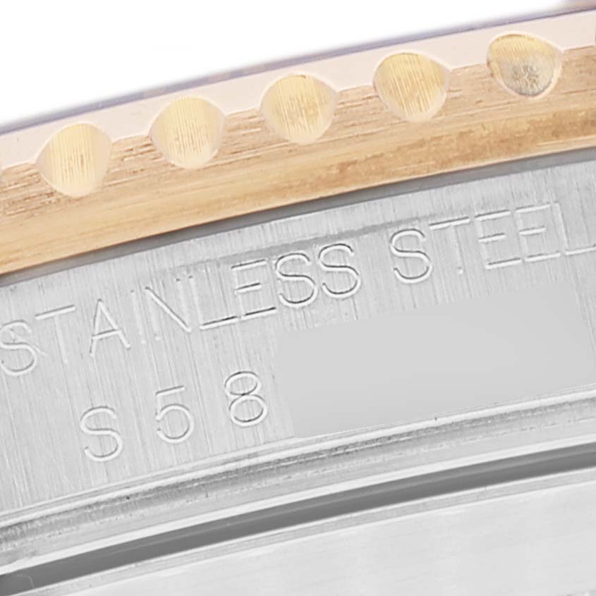 This close-up image shows the edge of the bezel and part of the case of a Rolex Submariner 16613 Men
s Steel and Gold (two tone) Blue Dial 16613 Men
s Steel and Gold (two tone) Blue Dial watch, highlighting the "STAINLESS STEEL" engraving.