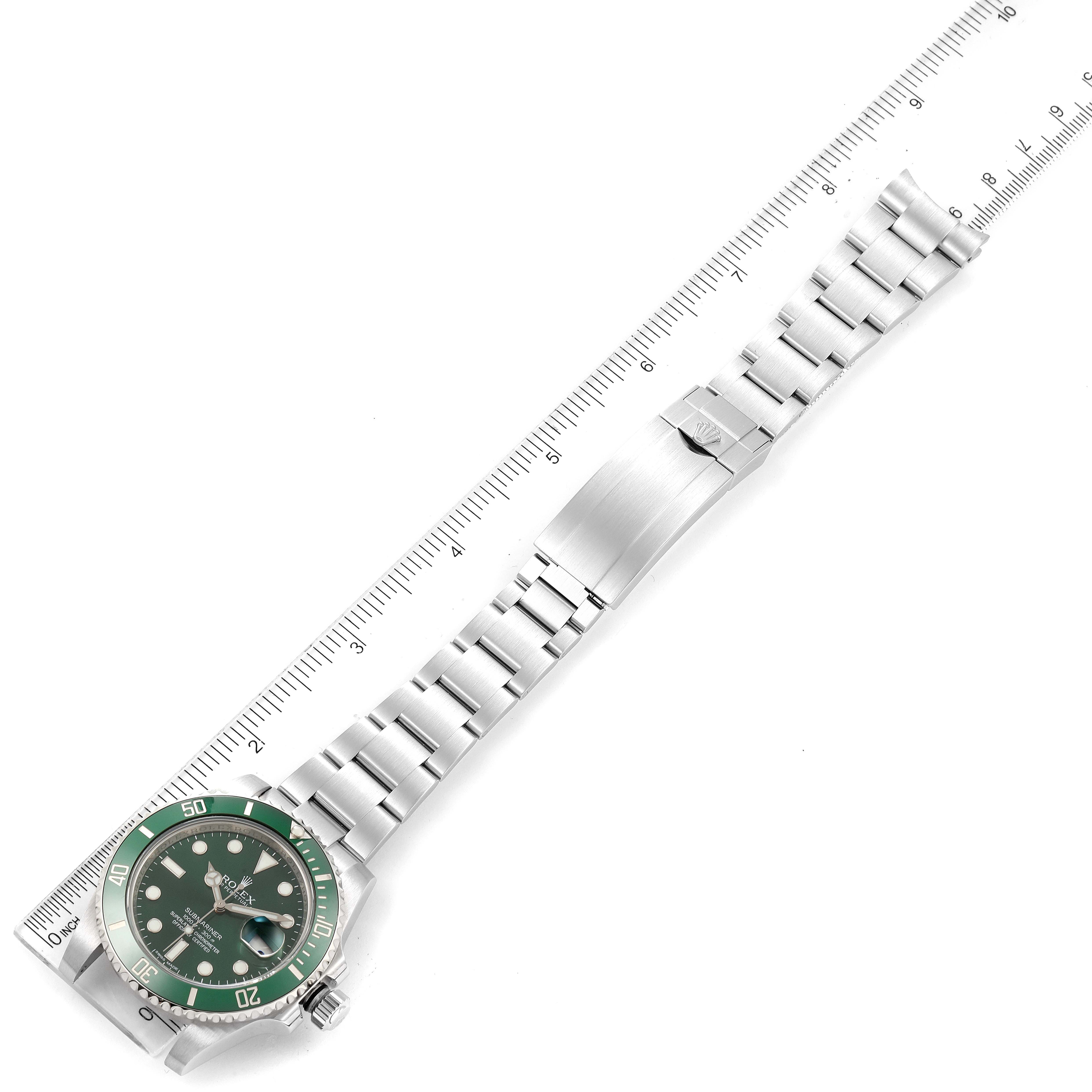 The image shows a Rolex Submariner 116610LV Men
s Stainless Steel Green Dial 116610LV Men
s Stainless Steel Green Dial watch laid flat with a ruler next to it, displaying the dial, bracelet, and clasp.