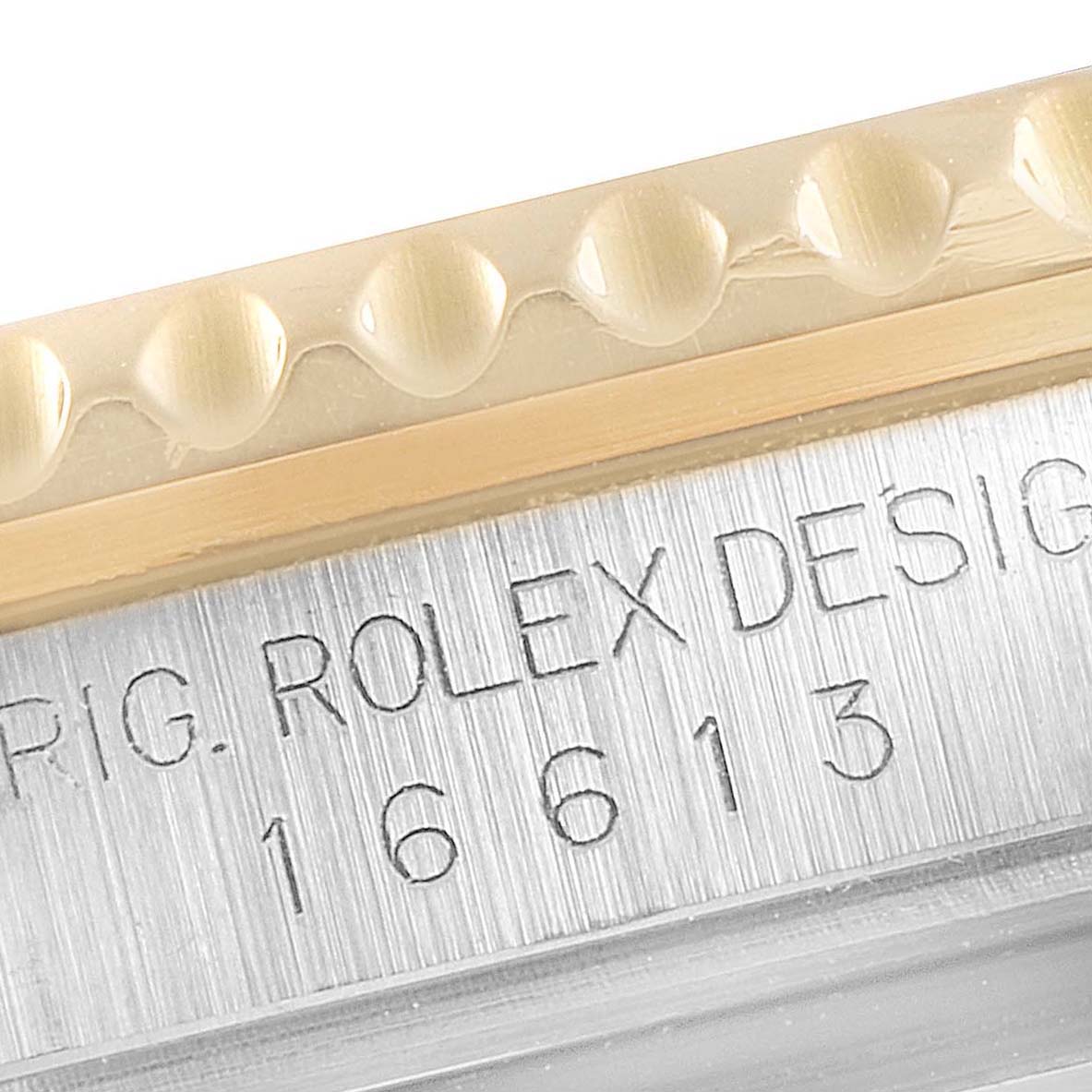 This image shows a close-up of the Rolex Submariner 16613 Men's Steel and Gold (two tone) Black Dial 16613 Men's Steel and Gold (two tone) Black Dial model's bezel and engraved serial number.