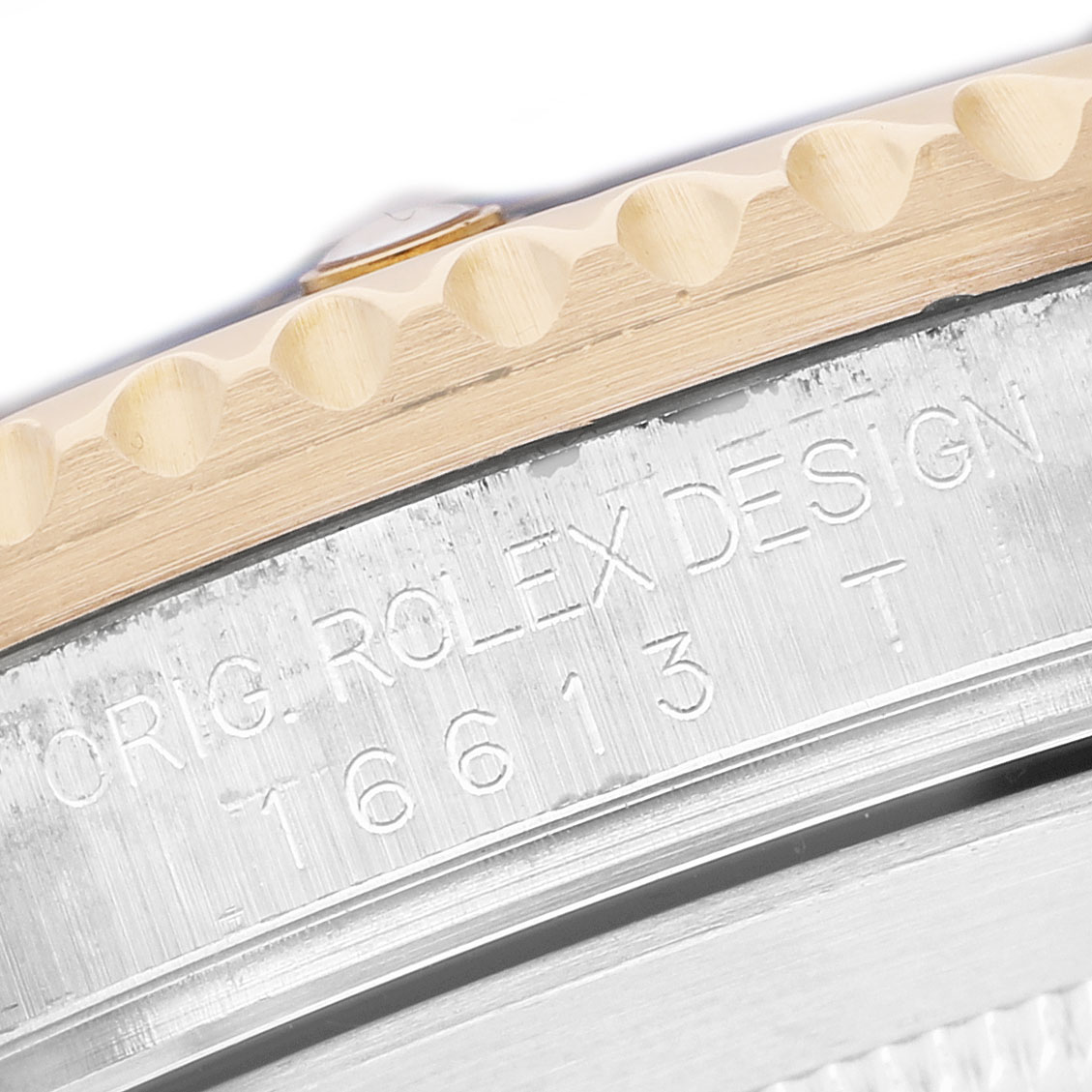 The image shows a close-up of the edge and engravings on the bezel and case of a Rolex Submariner 16613 Men's Steel and Gold (two tone) Black Dial.