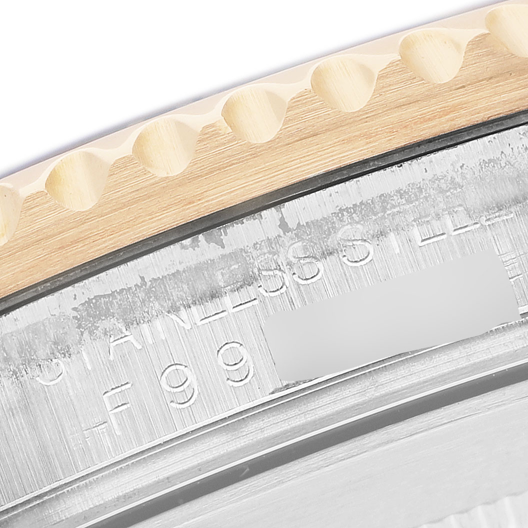 The image shows a close-up of the bezel and engraved edge of a Rolex Submariner 16613 Men's Steel and Gold (two tone) Black Dial watch, highlighting the text and metal finish.