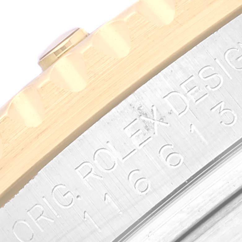 This close-up angle shows the engraved edge of a Rolex Submariner 116613 Men's Steel and Gold (two tone) Blue Dial 116613 Men's Steel and Gold (two tone) Blue Dial watch case, highlighting the bezel and part of the serial number.