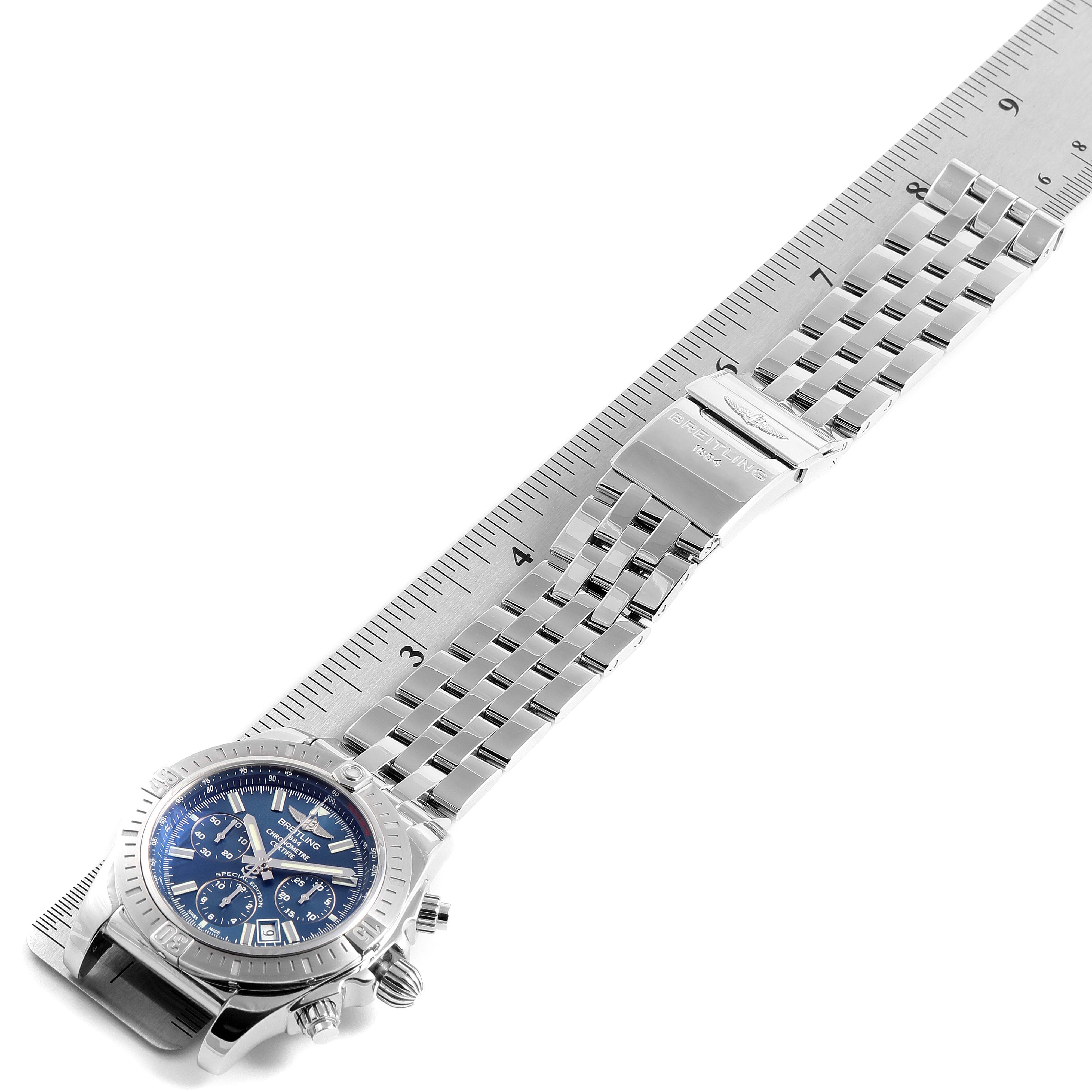 The Breitling Chronomat AB0115 Men
s Stainless Steel Blue Dial AB0115 Men
s Stainless Steel Blue Dial watch is shown from a top-down angle along a ruler, displaying its dial, bracelet, and clasp.