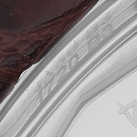 The image shows a close-up of the edge of a Breitling Navitimer A17325 Men's Stainless Steel Blue Dial with part of the strap and engraved markings visible.