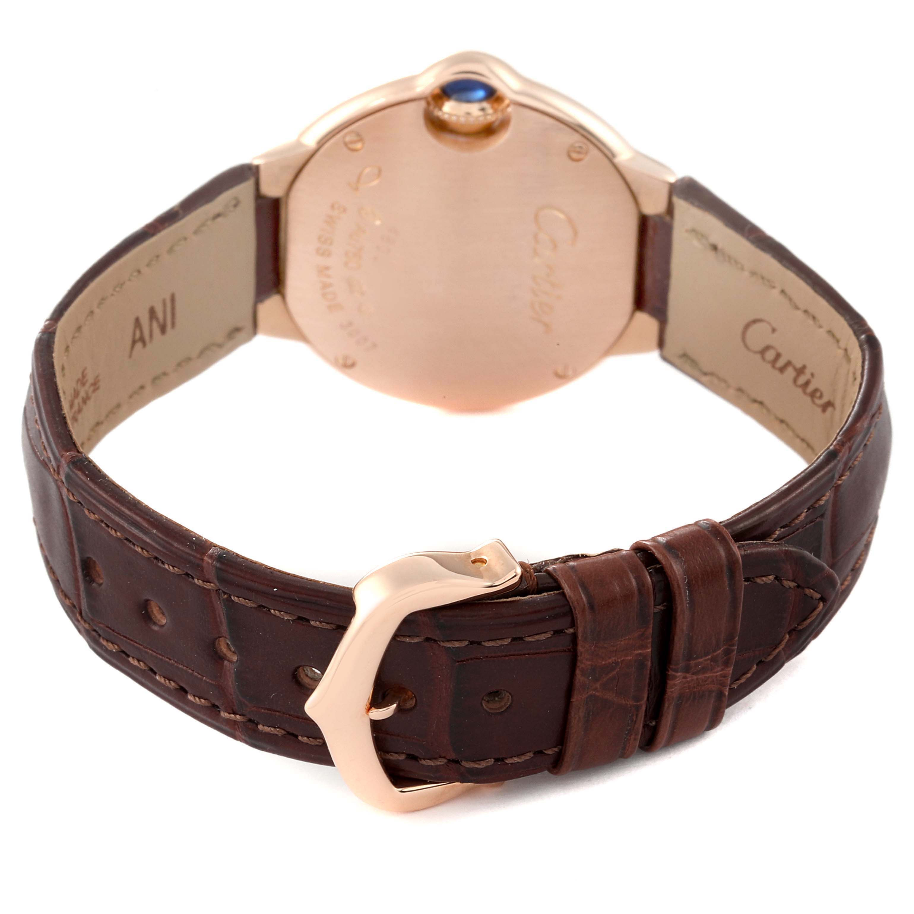 The image shows the back case and brown leather strap of a Cartier Ballon Bleu WE902050 Women's Rose Gold Silver Dial WE902050 Women's Rose Gold Silver Dial watch, highlighting its buckle and caseback engravings.