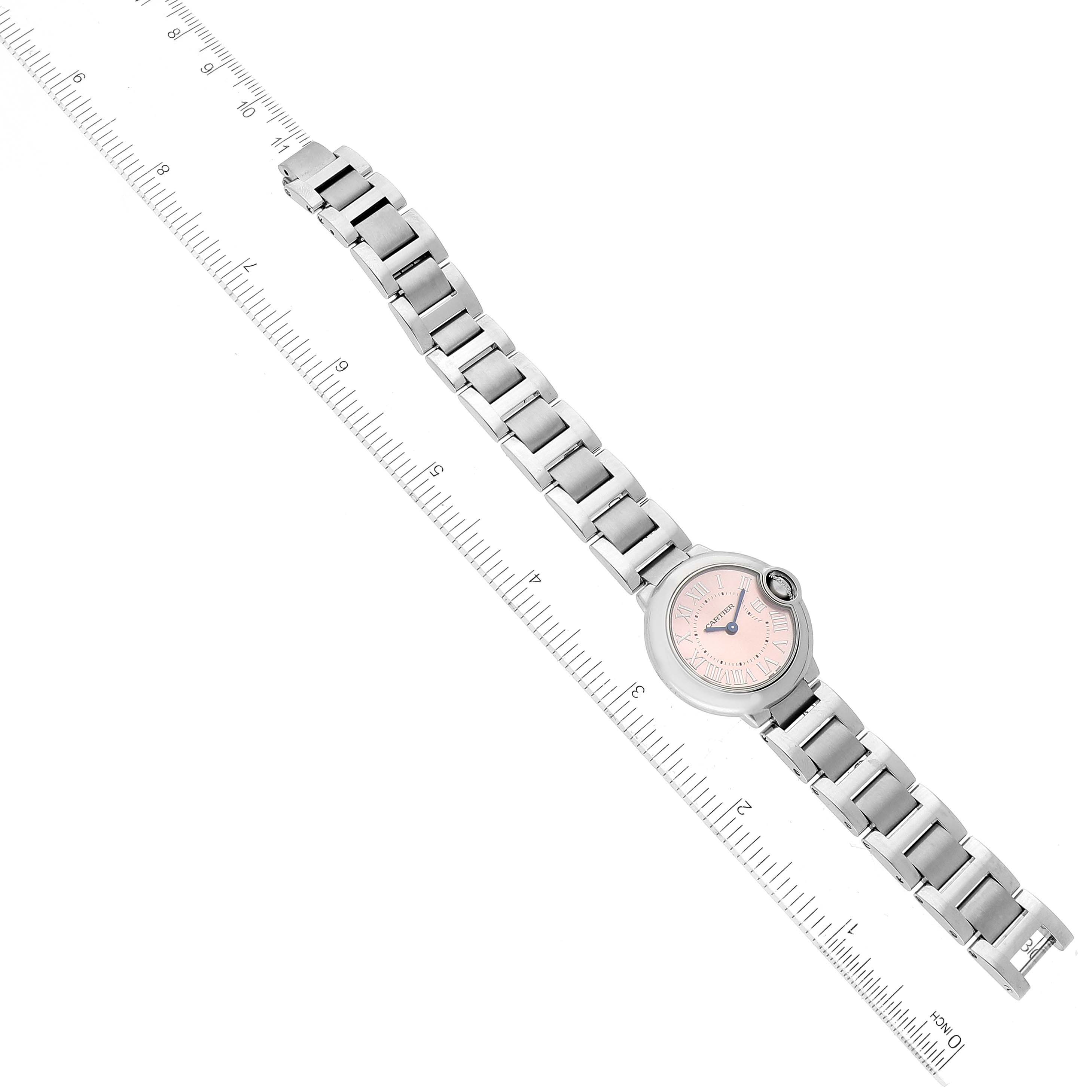 The Cartier Ballon Bleu W6920038 Women's Stainless Steel Pink Dial W6920038 Women's Stainless Steel Pink Dial watch is shown in a top view, displaying its full bracelet and face next to a ruler for scale.