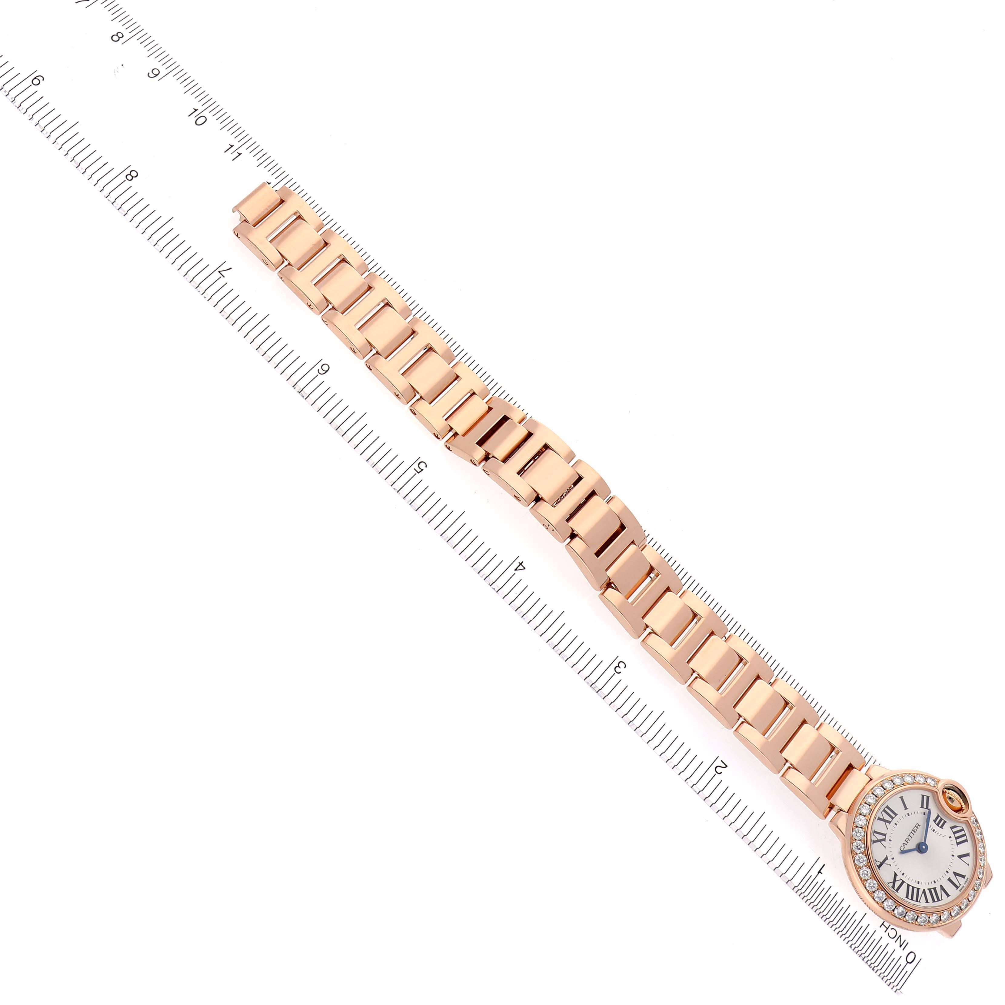 The Cartier Ballon Bleu WE9002Z3 Women's Rose Gold Silver Dial WE9002Z3 Women's Rose Gold Silver Dial watch is shown from a top-down angle, displaying the full bracelet and face against a ruler.