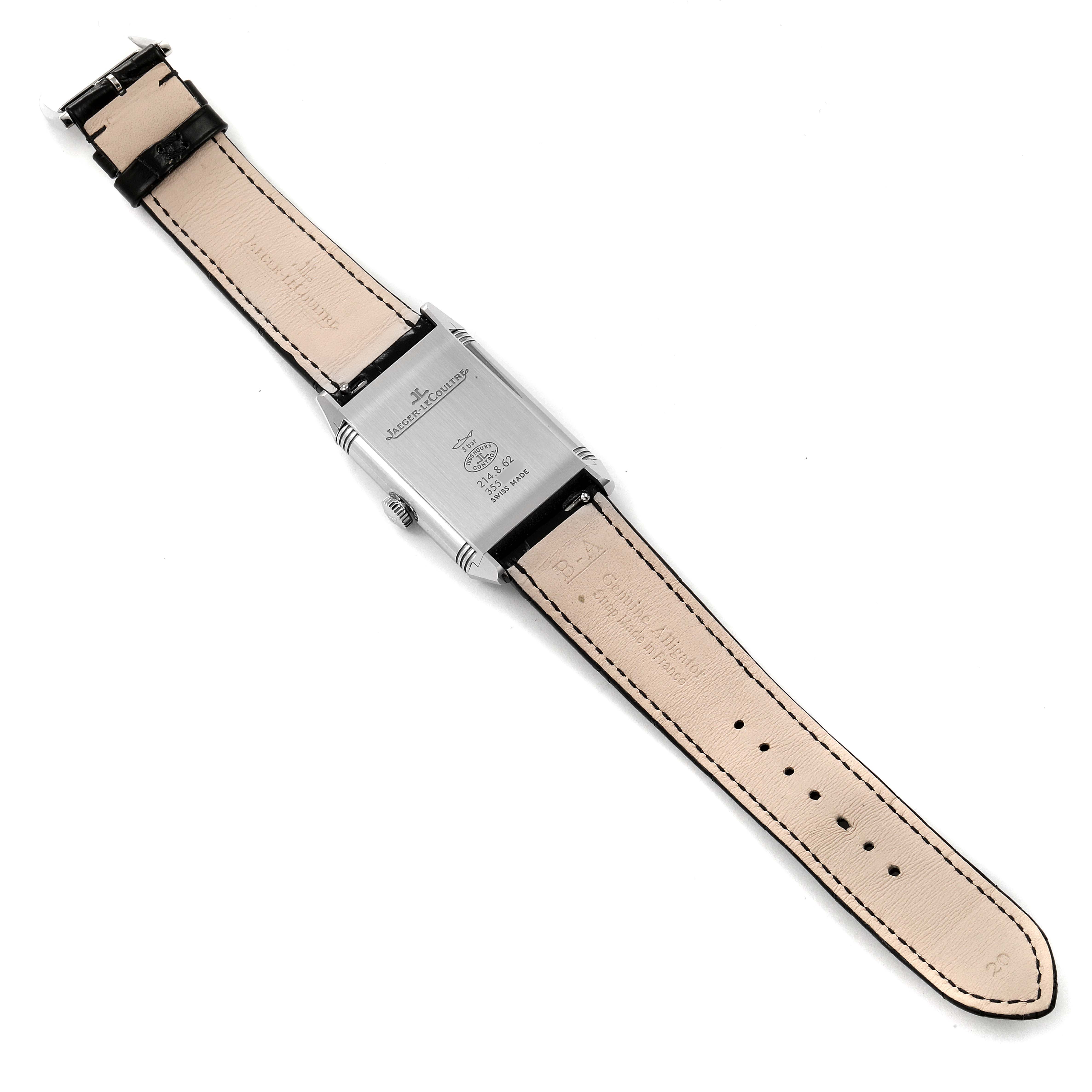 The image shows the back view of a Jaeger-LeCoultre Reverso watch with a beige leather strap and visible branding details.