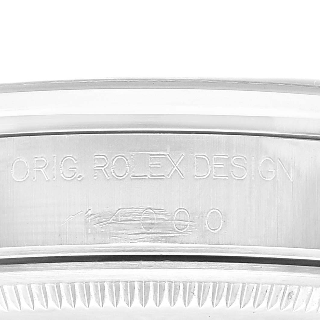 This close-up image shows the engraved side of the bezel on a Rolex Air-King 14000 Men's Stainless Steel Blue Dial 14000 Men's Stainless Steel Blue Dial watch, featuring the inscription "ORIG. ROLEX DESIGN."