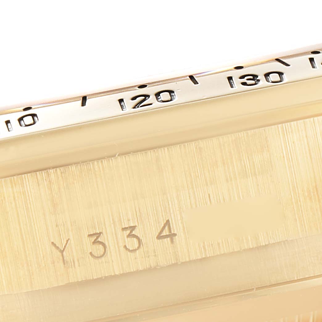 The image shows a close-up of the bezel and serial number engraving on a Rolex Daytona 116528 Men's Yellow Gold Black Dial 116528 Men's Yellow Gold Black Dial watch.