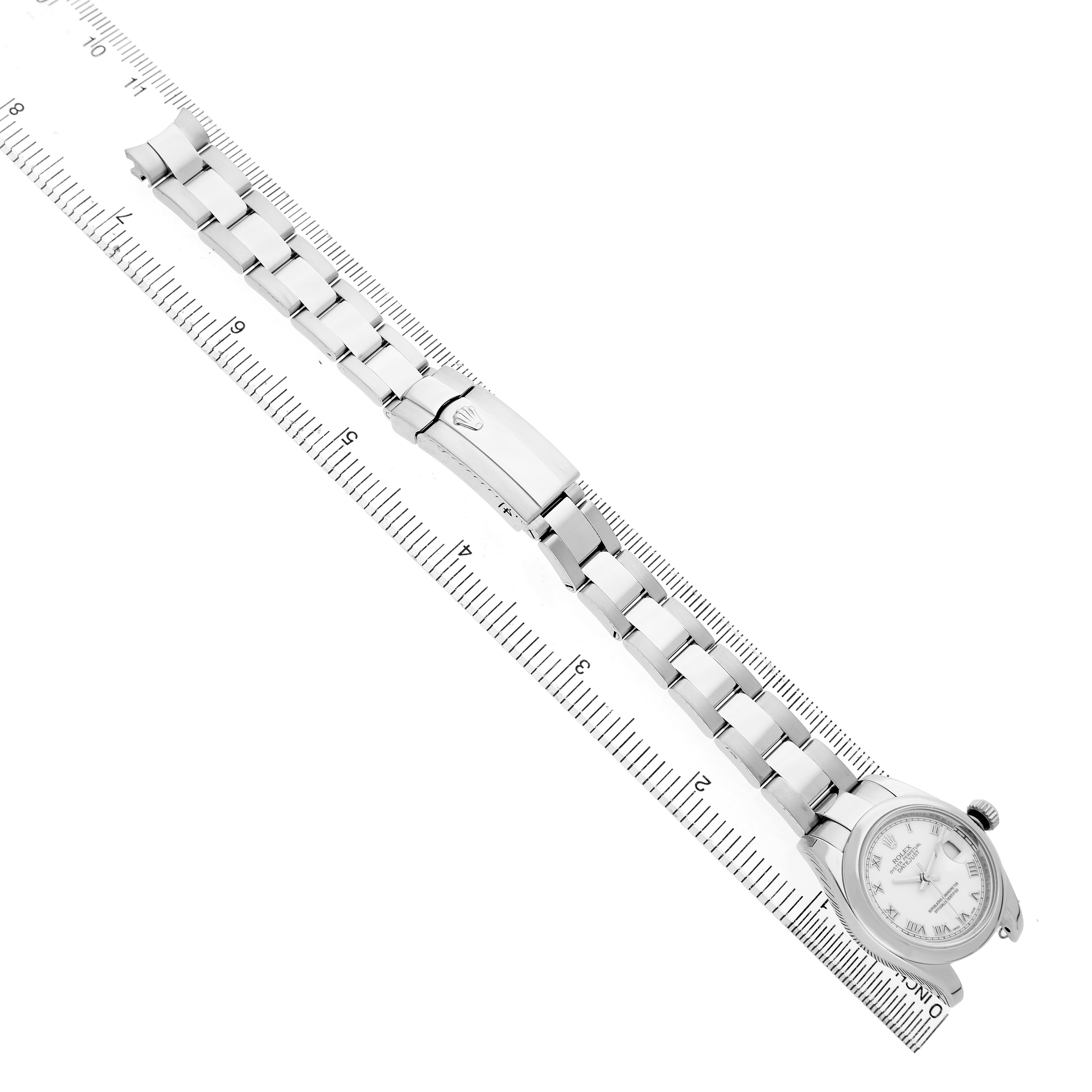 The image shows a Rolex Datejust 179160 Women's Stainless Steel White Dial watch laid flat alongside a ruler, highlighting the bracelet and face.