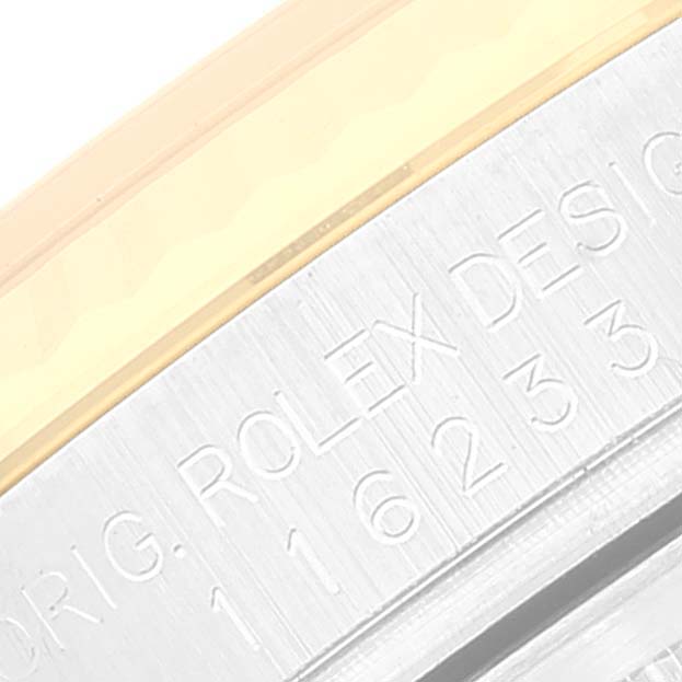 The image shows a close-up of the Datejust model by Rolex, focusing on the engraved serial numbers and "Rolex Design" text.