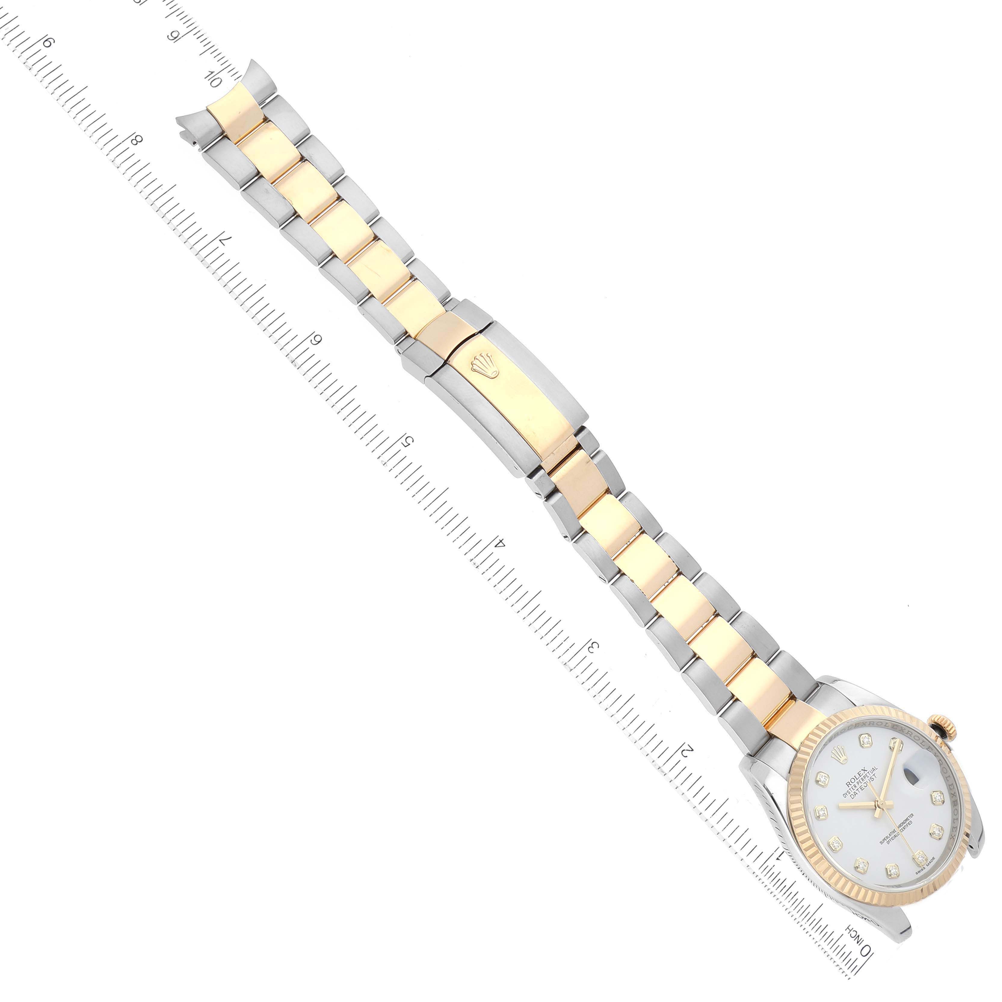 The Rolex Datejust 116233 Men's Steel and Gold (two tone) White Dial watch is shown from above, displaying the bracelet, clasp, and face, aligned with a ruler.