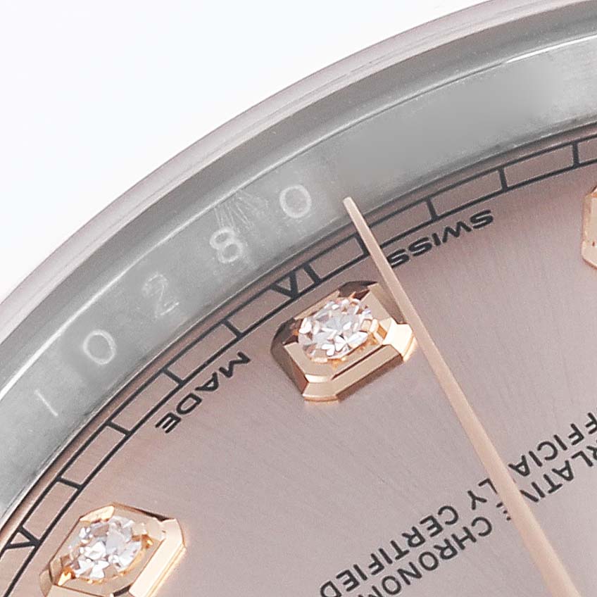 The image shows a close-up of the Rolex Datejust 41 126301 Men's Steel and Gold (two tone) Pink Dial 126301 Men's Steel and Gold (two tone) Pink Dial's dial, featuring a diamond hour marker and partial text.