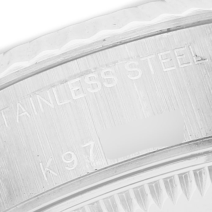 The image shows a close-up of the side, focusing on the engravings and the fluted bezel of a Rolex Datejust 79174 Women's Stainless Steel Mother of Pearl Dial.