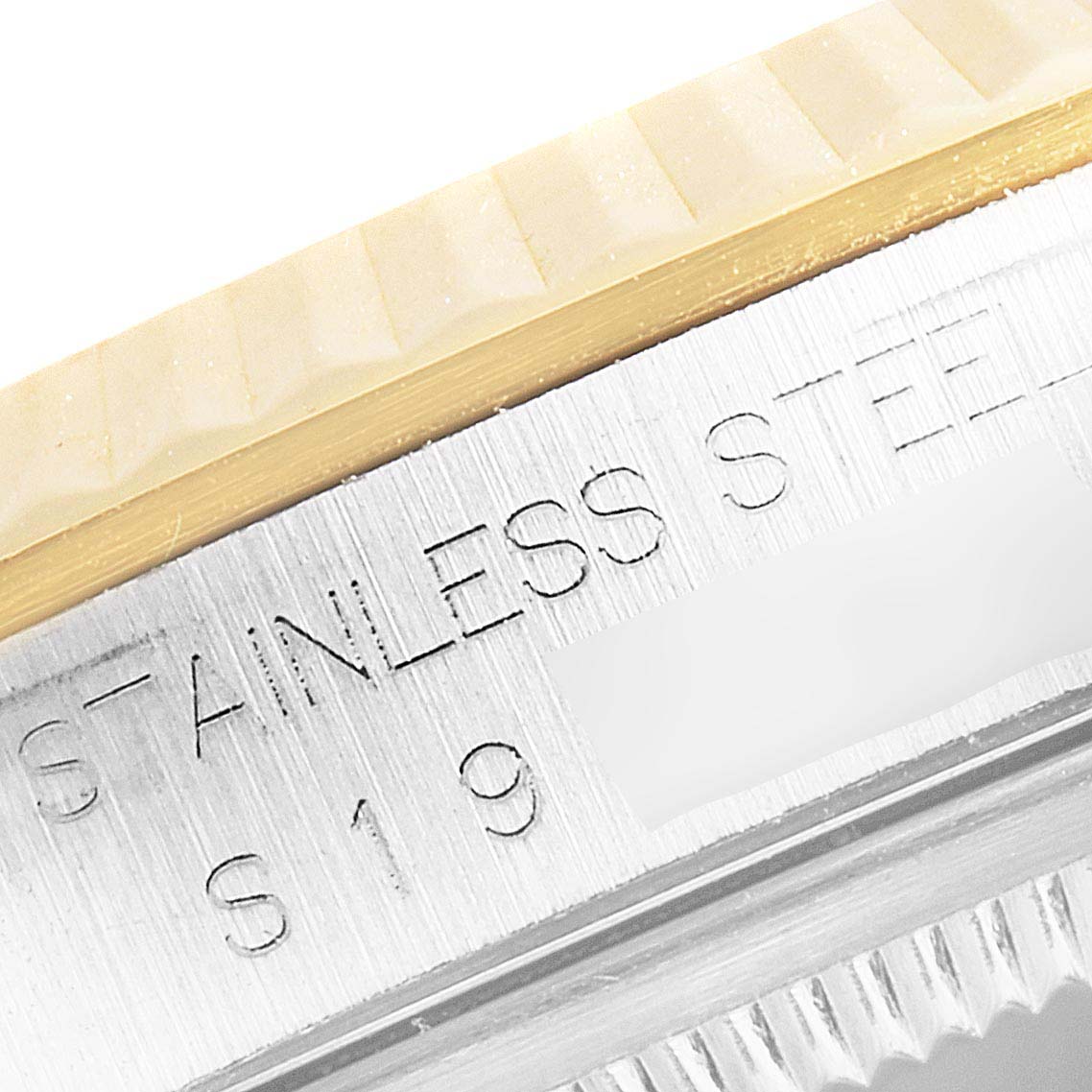 The image shows a close-up of the side of a Rolex Datejust 16233 Men's Stainless Steel Champagne Dial 16233 Men's Stainless Steel Champagne Dial watch, highlighting the stainless steel part with engraved text.