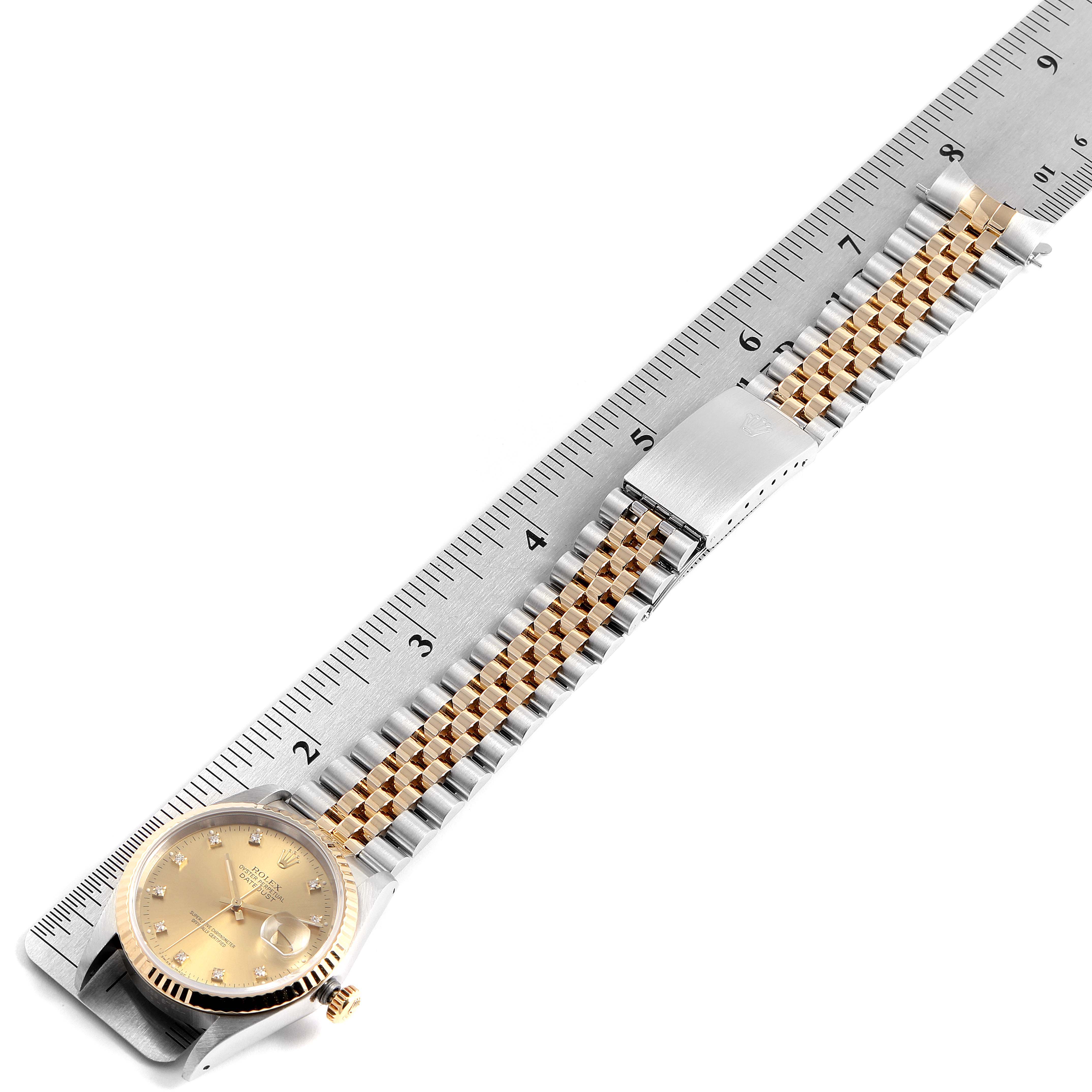 The Rolex Datejust 16233 Men's Steel and Gold (two tone) Champagne Dial 16233 Men's Steel and Gold (two tone) Champagne Dial watch is shown from a top view, displaying the face, crown, and full bracelet alongside a ruler for scale.