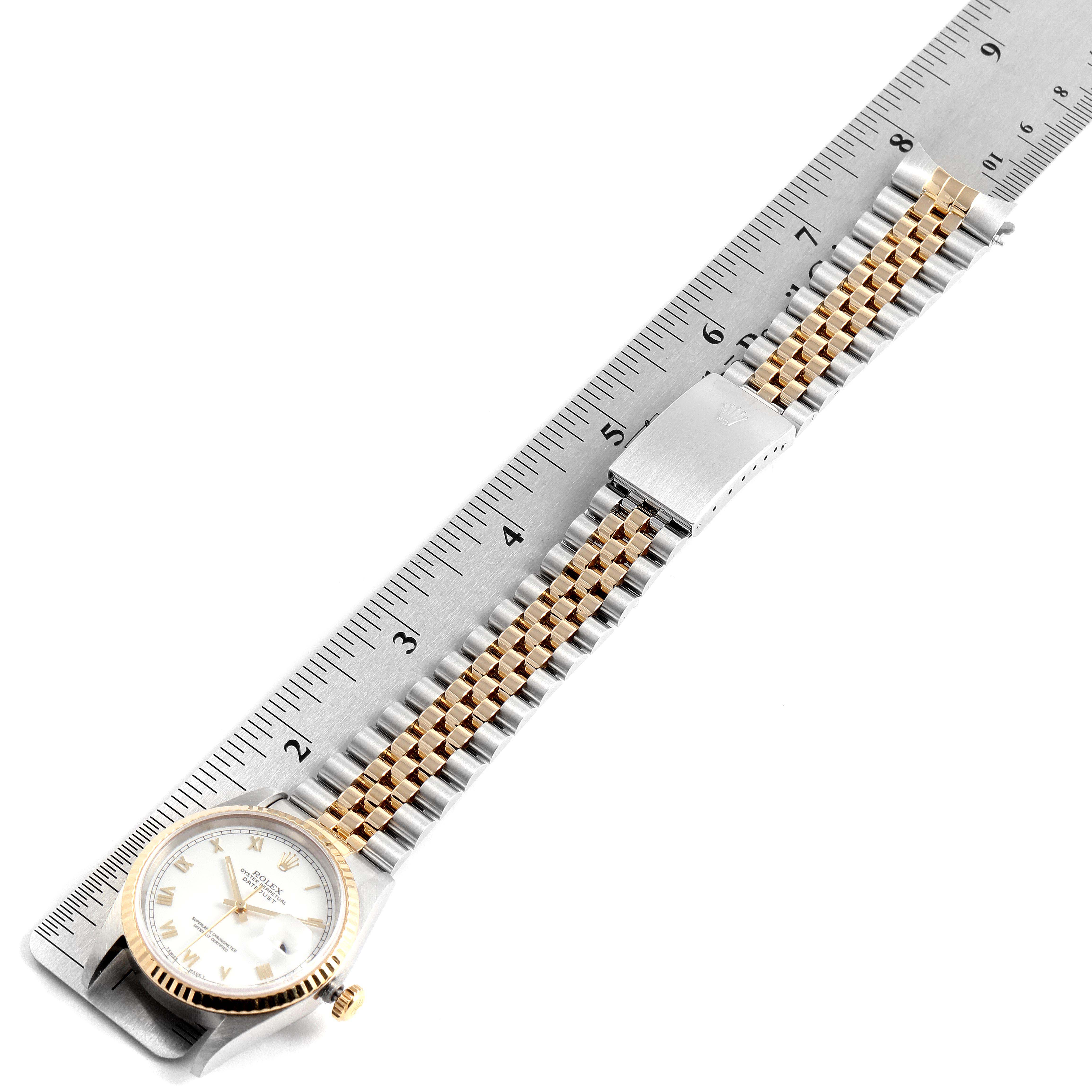 The Rolex Datejust 16233 Men's Steel and Gold (two tone) White Dial 16233 Men's Steel and Gold (two tone) White Dial watch is shown laying flat with a ruler, displaying the face and metal bracelet fully.