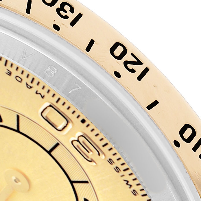 The image shows a close-up of the Rolex Daytona 116523 Men's Steel and Gold (two tone) Champagne Dial bezel angled to reveal part of the dial with numbers and markers.