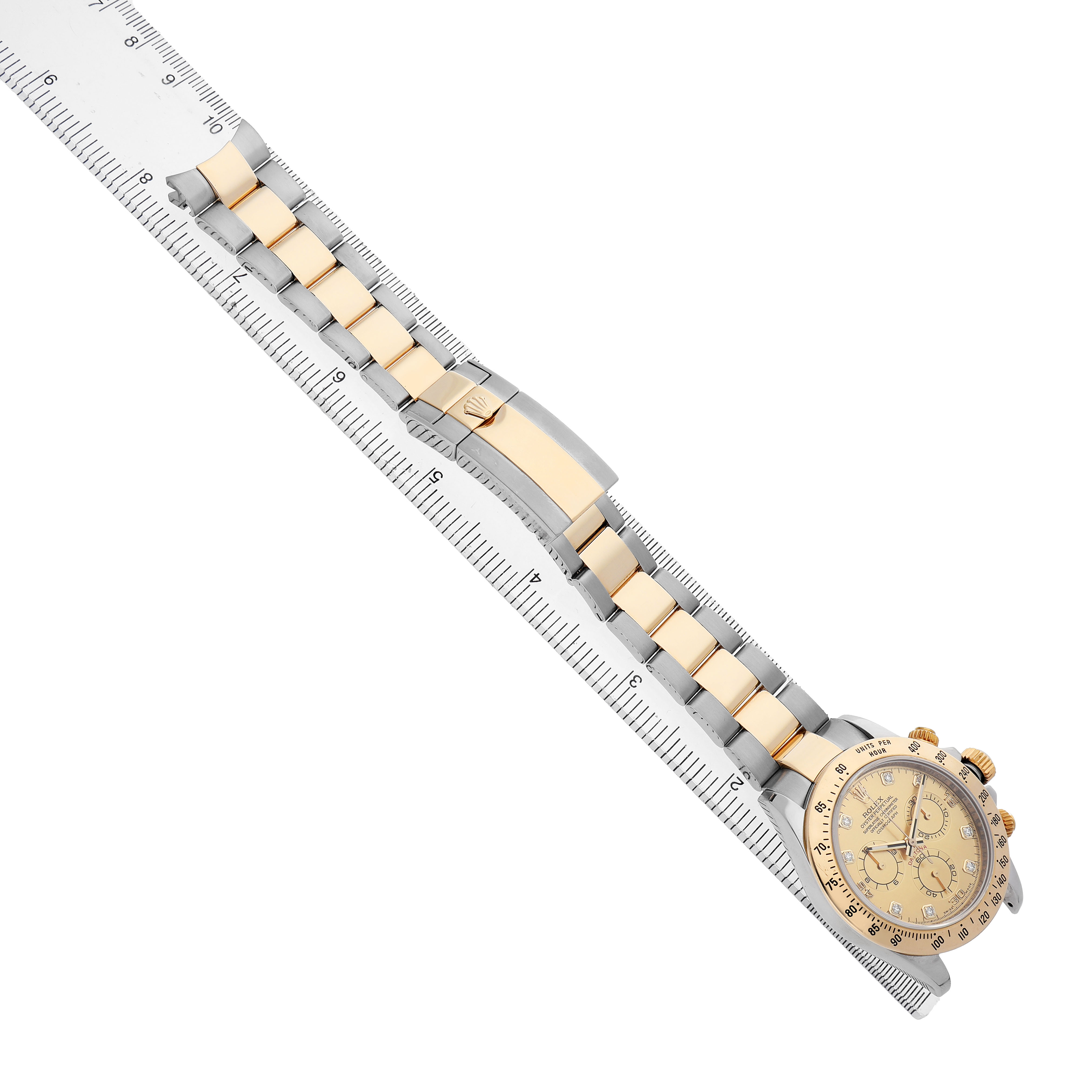 The Rolex Daytona 116523 Men's Steel and Gold (two tone) Champagne Dial watch is shown diagonally, displaying its face and bracelet alongside a ruler for size reference.