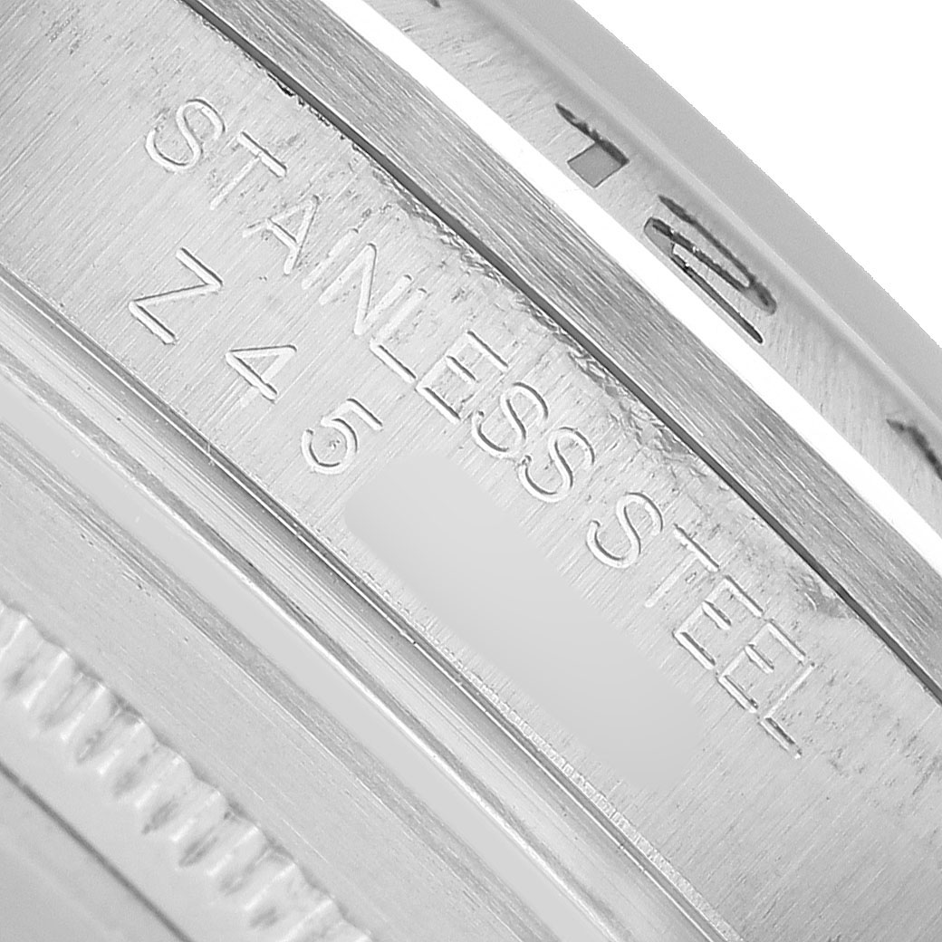The image shows a close-up of the inner bezel with "STAINLESS STEEL" engraving on a Rolex Explorer 16570 Men's Stainless Steel White Dial watch.