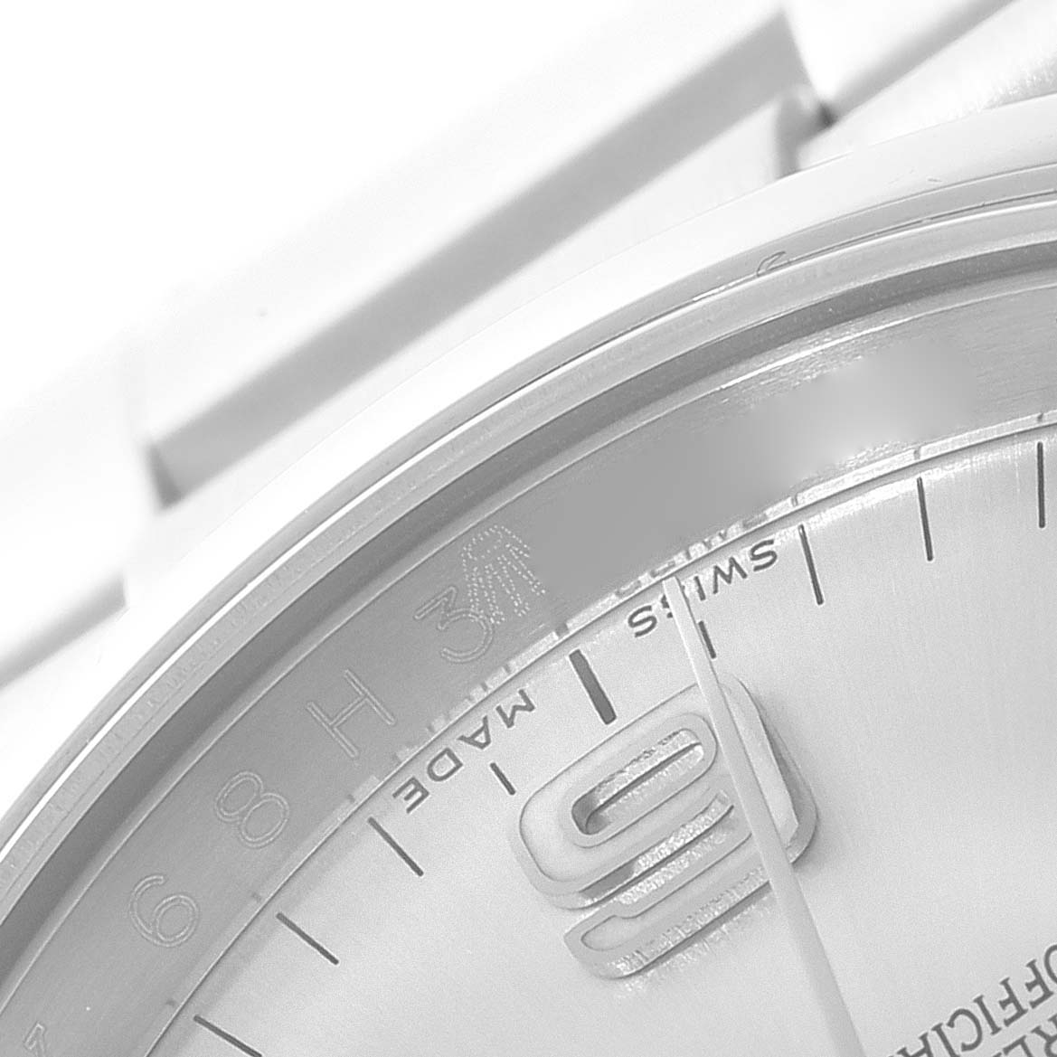 The image shows a close-up of the dial and part of the bezel of the Rolex Oyster Perpetual 116000 Men's Stainless Steel Silver Dial 116000 Men's Stainless Steel Silver Dial watch.