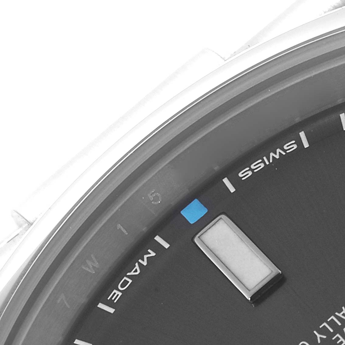 The close-up image shows part of the dial of the Rolex Oyster Perpetual 114300 Men's Stainless Steel Grey Dial 114300 Men's Stainless Steel Grey Dial watch, focusing on the "SWISS MADE" text and part of the hour markers.