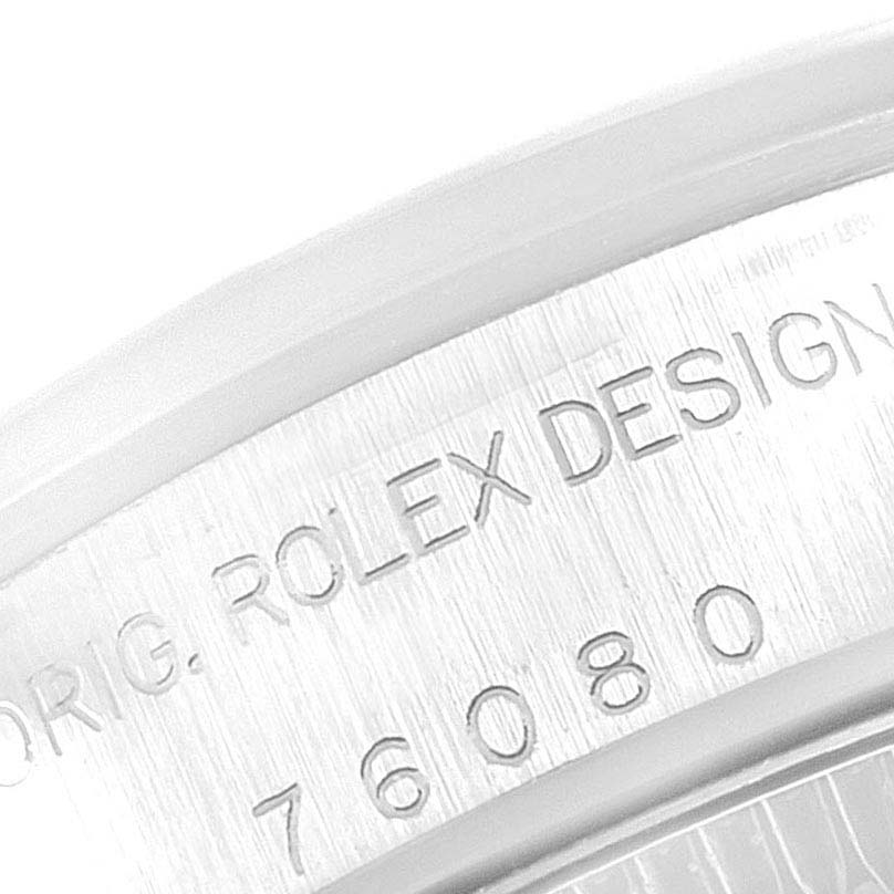 This close-up image of the Rolex Oyster Perpetual 76080 Women's Stainless Steel Black Dial 76080 Women's Stainless Steel Black Dial model shows the engraved design number "76080" and "ORIG. ROLEX DESIGN" on the case back rim.