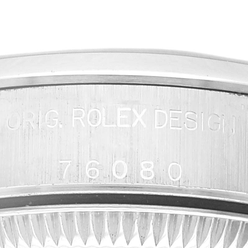 The image shows a close-up of the side engraving on the bezel of a Rolex Oyster Perpetual 76080 Women
s Stainless Steel Pink Dial 76080 Women
s Stainless Steel Pink Dial watch, displaying "ORIG. ROLEX DESIGN 76080".
