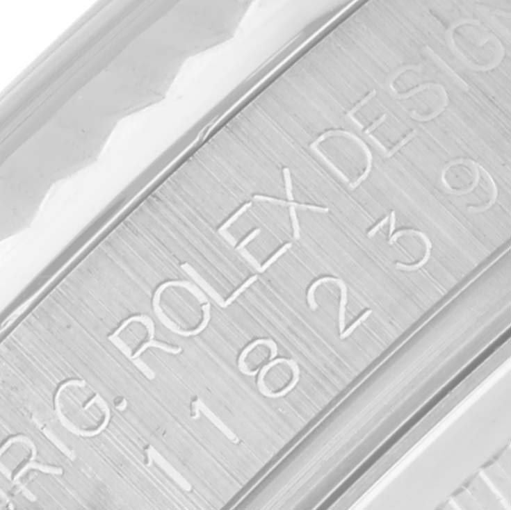The image shows a close-up of the Rolex President 118239A Men's White Gold Silver Dial 118239A Men's White Gold Silver Dial model's side, highlighting engravings on the case.