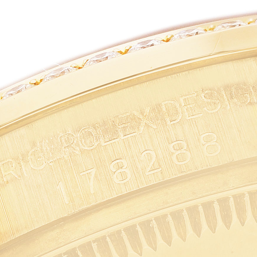 The image shows a close-up of the edge of a Rolex President 178288 Women's Yellow Gold Mother of Pearl Dial model watch, highlighting the engraved bezel and serial number.