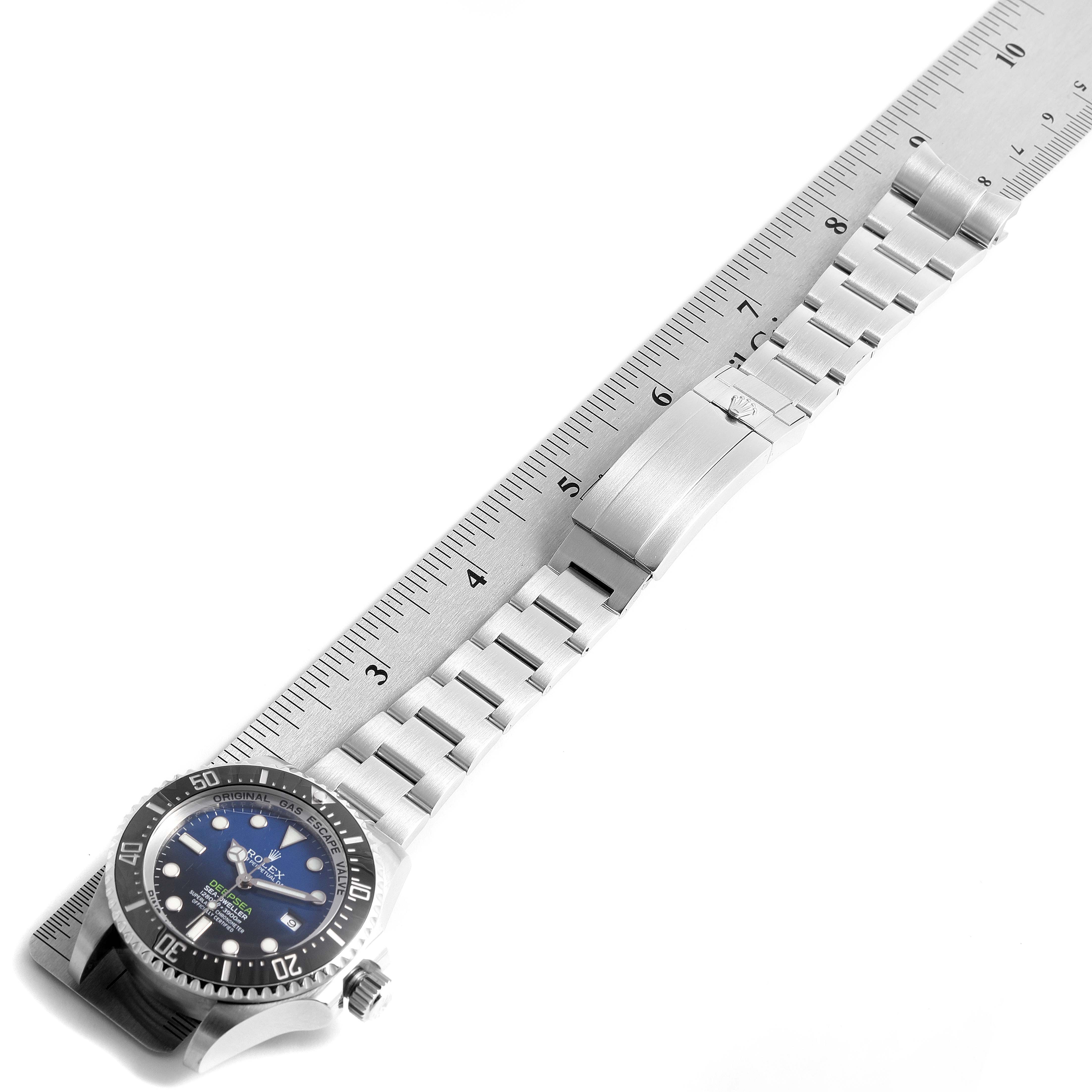 The image shows a Rolex Sea-Dweller 116660 Men's Stainless Steel Blue Dial 116660 Men's Stainless Steel Blue Dial watch laid flat with its stainless steel band extended next to a ruler.