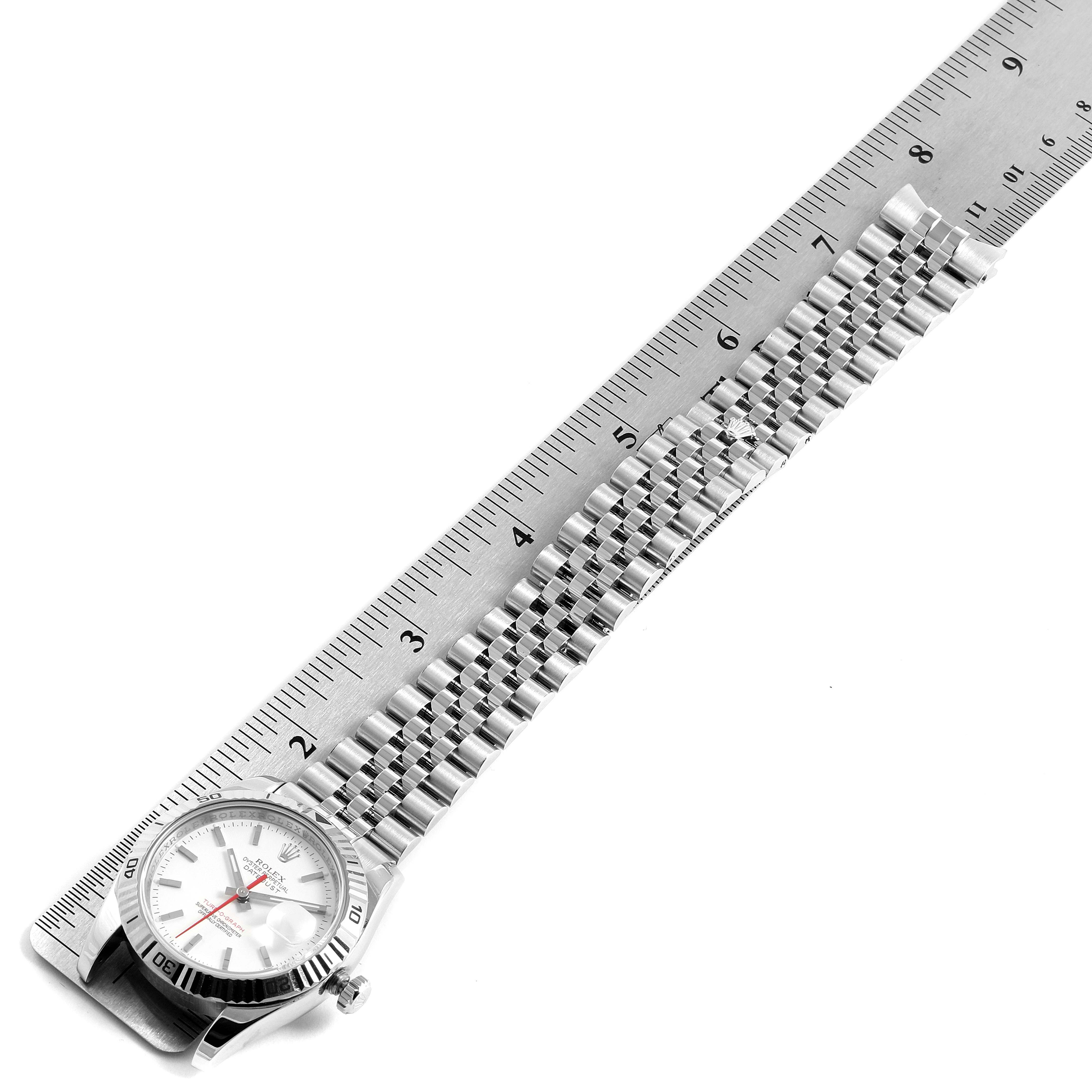 The image shows the side view of a Rolex Turn-o-Graph 116264 Men's Stainless Steel White Dial 116264 Men's Stainless Steel White Dial watch with its bracelet extended alongside a ruler for measurement.