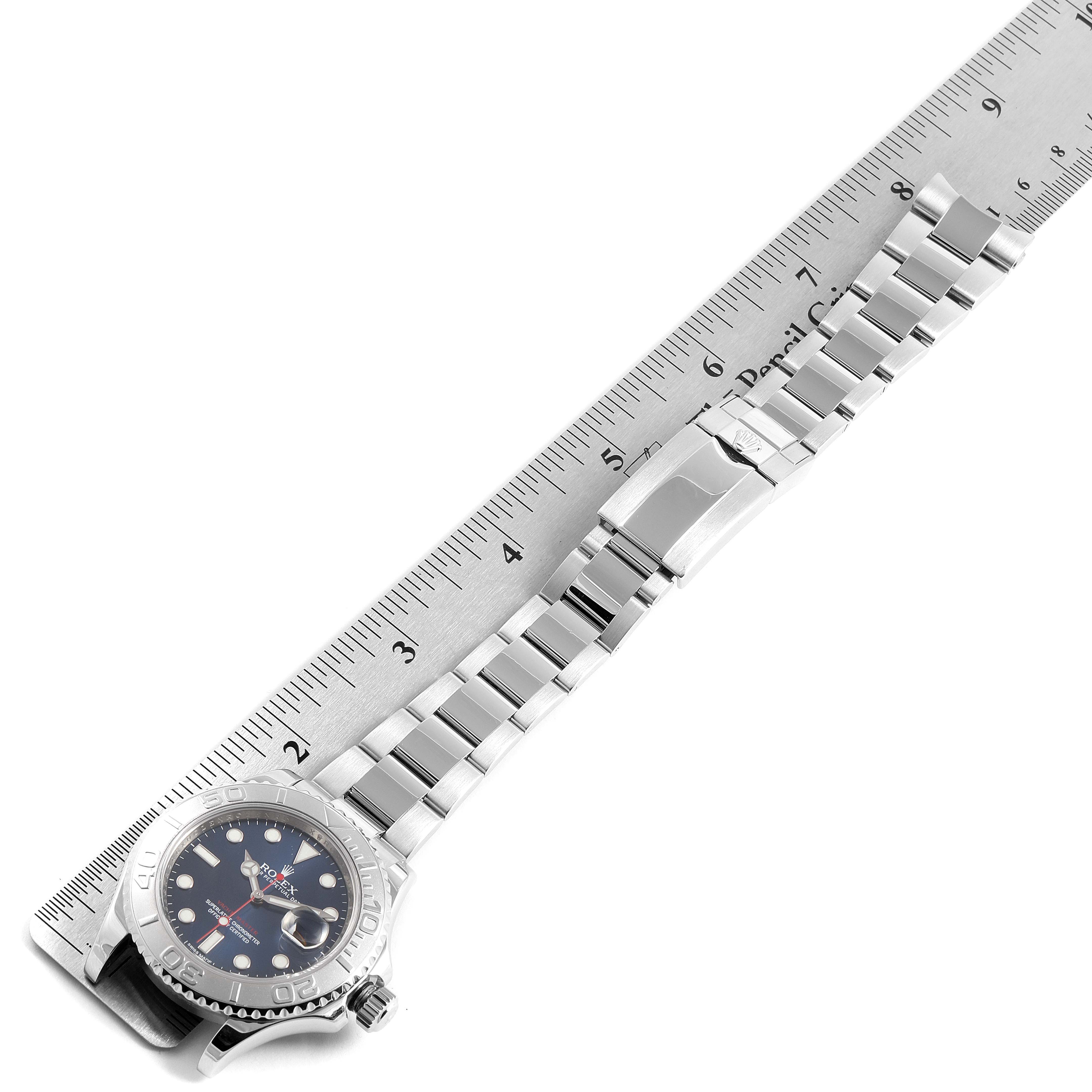 The image shows a Rolex Yacht-Master 116622 Men
s Stainless Steel Blue Dial 116622 Men
s Stainless Steel Blue Dial watch laid flat with its bracelet extended alongside a ruler for scale.