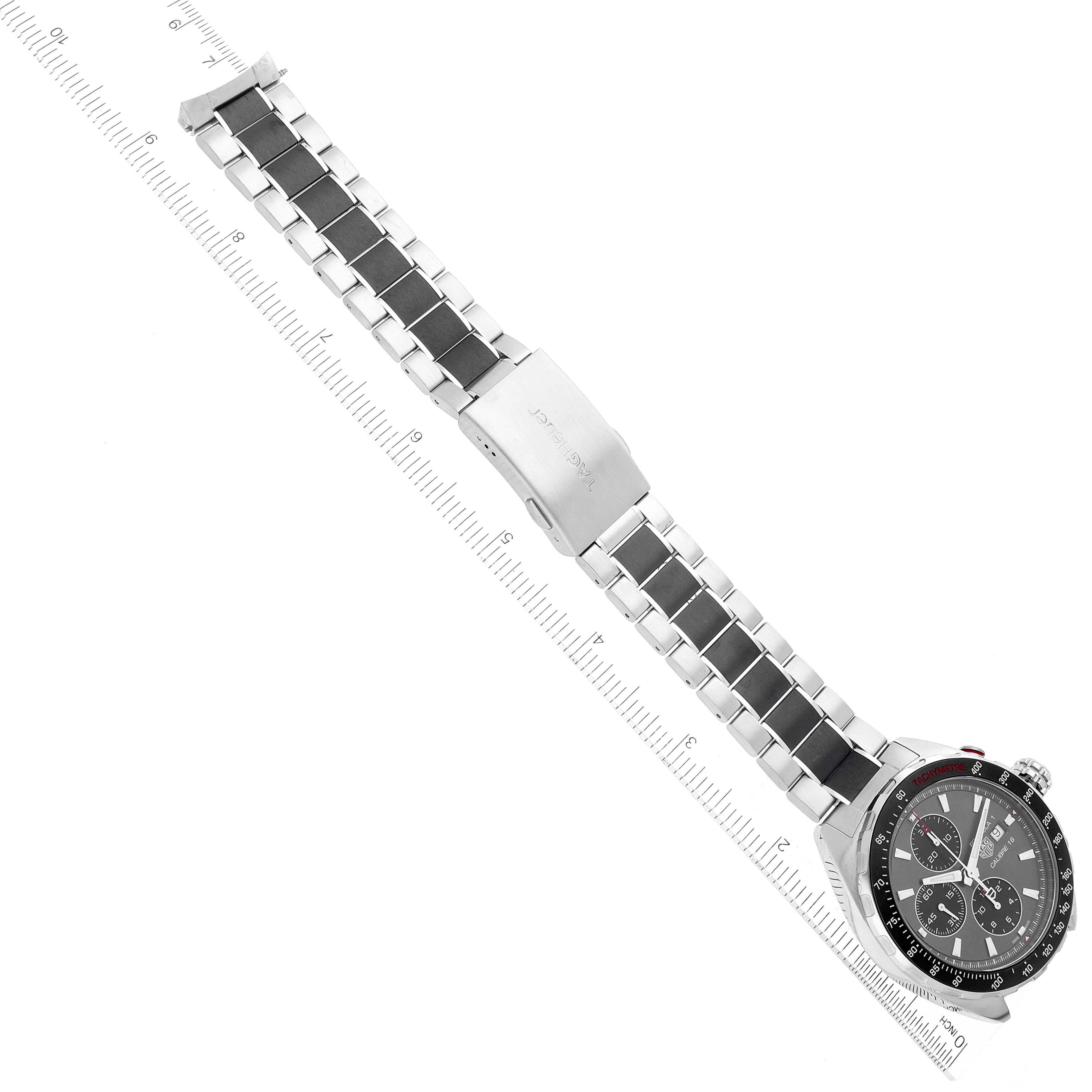 This image shows the Tag Heuer Formula 1 CAZ2012.BA0876 Men's Stainless Steel Grey Dial CAZ2012.BA0876 Men's Stainless Steel Grey Dial watch laid flat, showcasing the face, bezel, bracelet, and clasp, with a ruler for scale.
